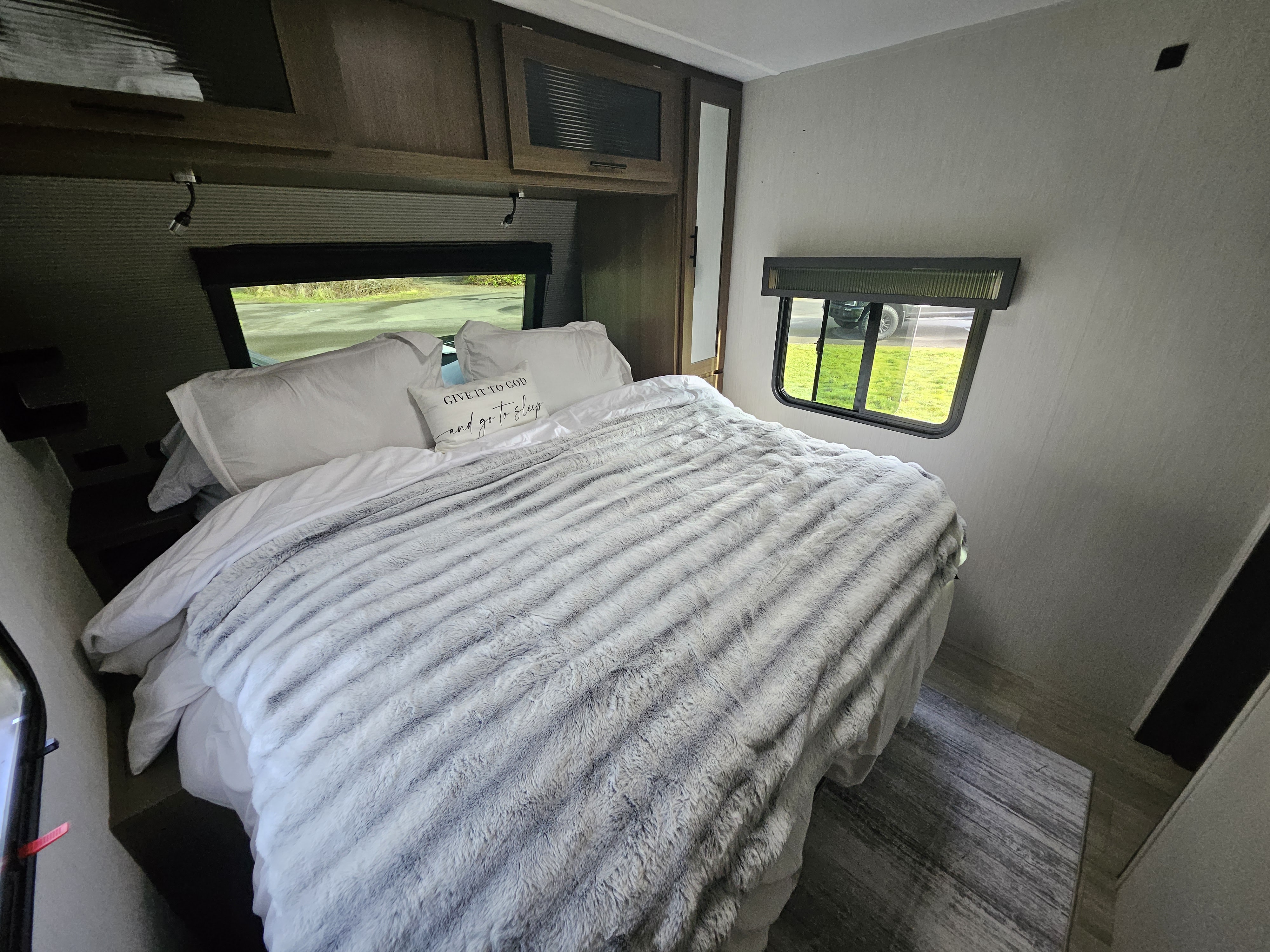 Cozy rv rental bedroom with a comfy bed, fluffy gray blanket, and natural light from the windows. Perfect for your travels.. Forest River Wildcat Maxx 2026