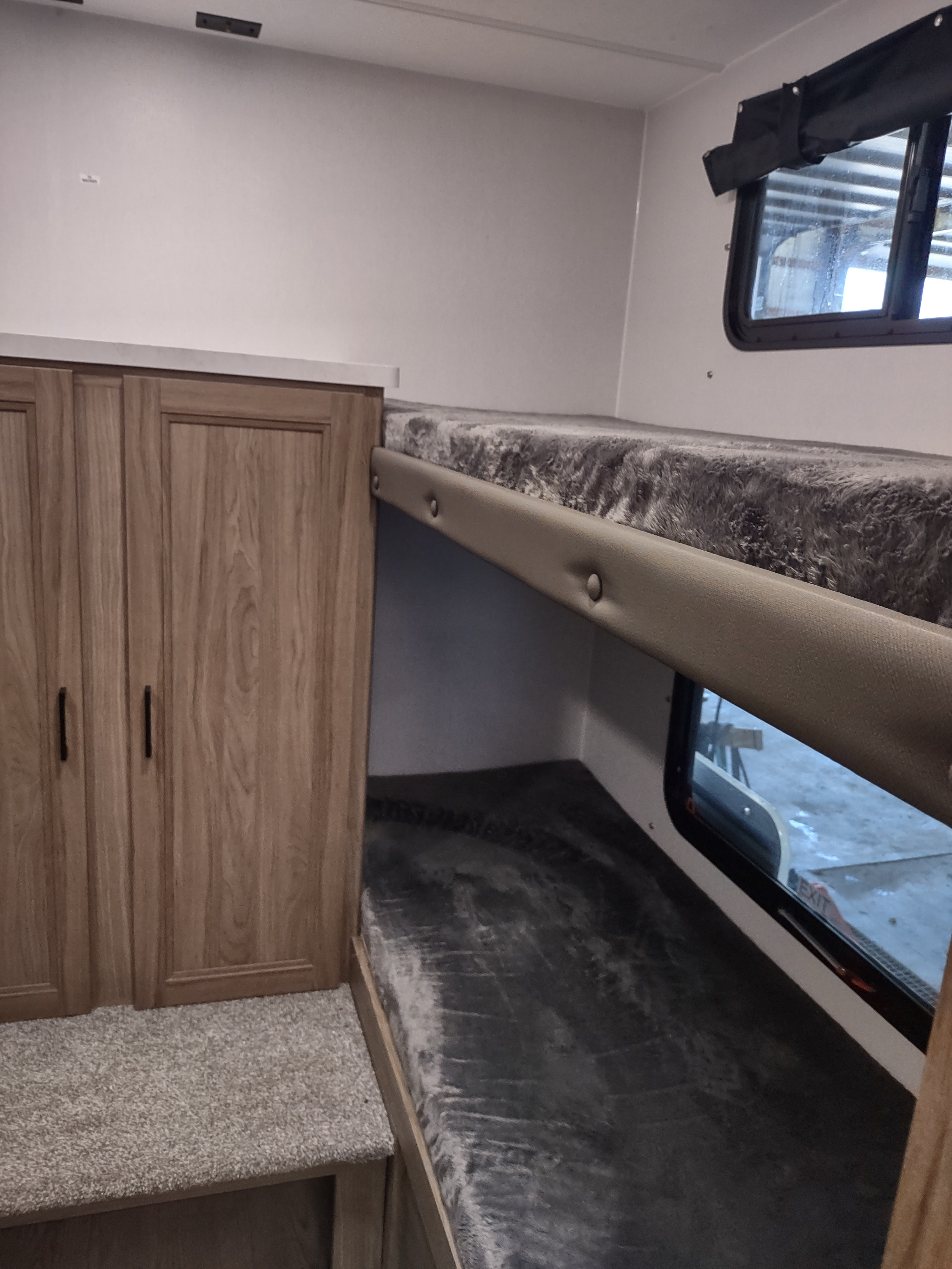 RV rental bunkhouse area: cozy upper & lower beds, wood-grain storage, and window. Ideal for family camping.. Coachmen 29 SE 2025