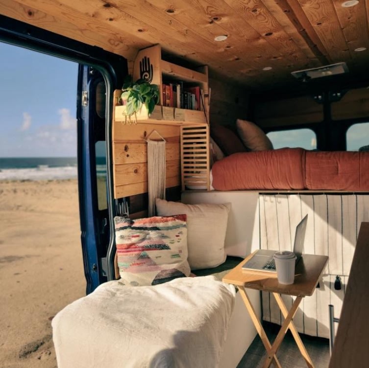 Cozy RV rental interior with ocean view from a camper van. Perfect for remote work & beach adventures.. Dodge Ram 1500 2021