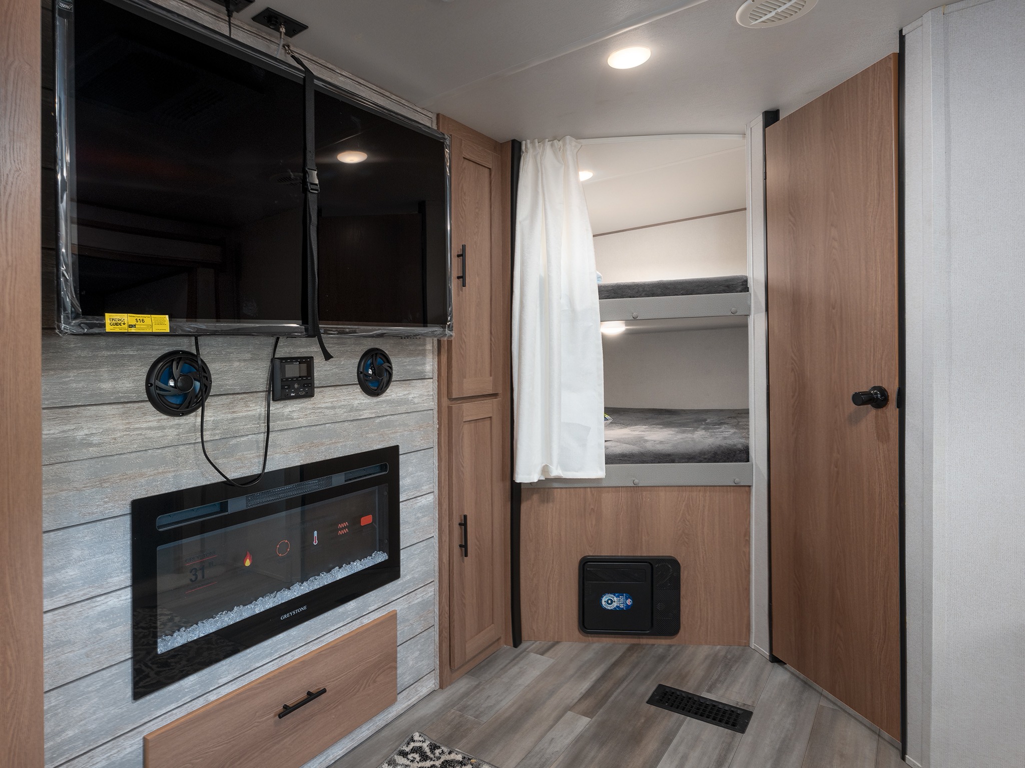 RV rental: living area featuring TV, electric fireplace, & bunk beds with a privacy curtain. Great for travel.. Prime Time Avenger 2024
