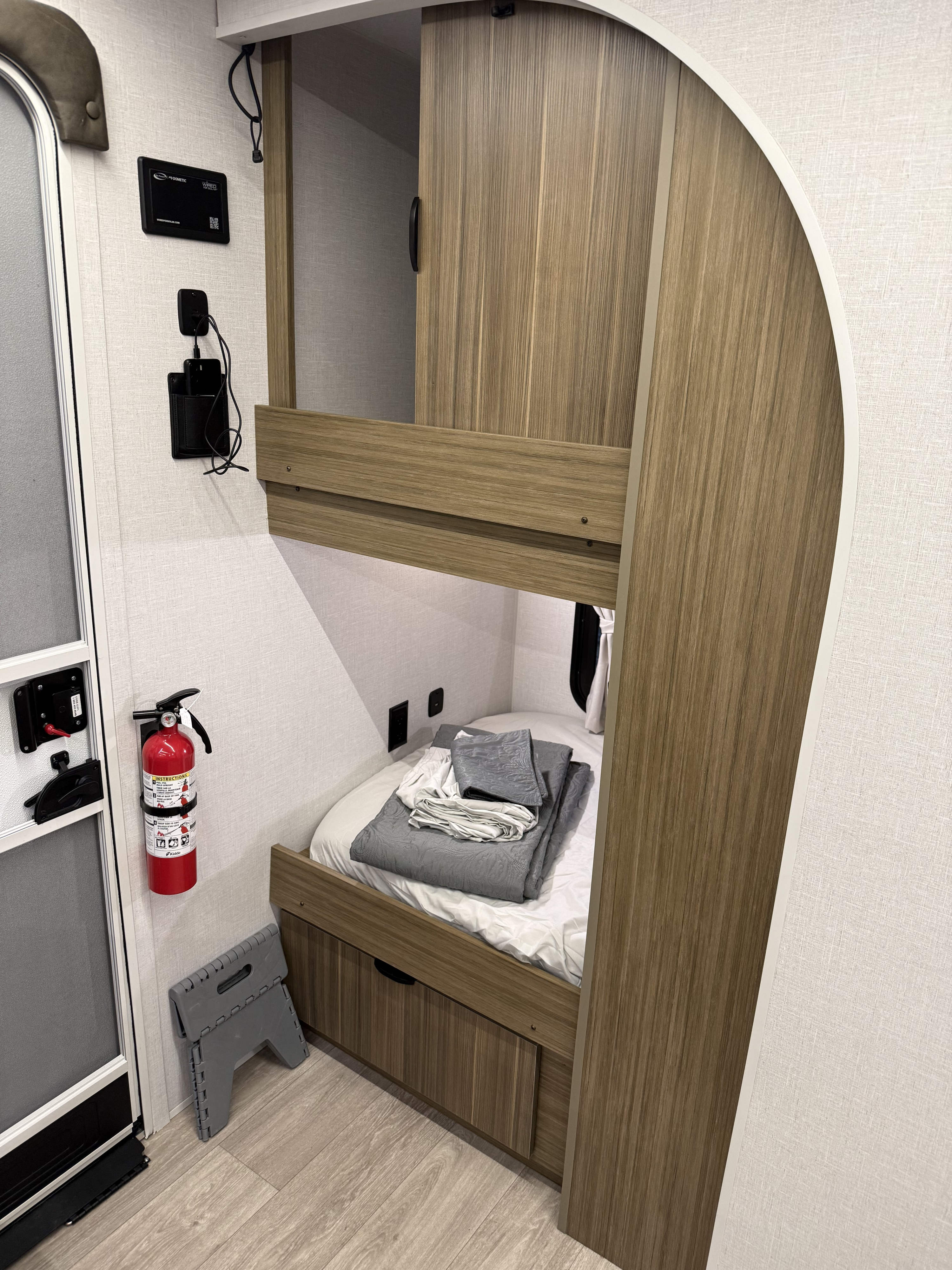 Cozy rv rental bunk bed area by entry door, featuring a fire extinguisher, Dometic controls, and USB chargers.. Forest River Salem Cruise-Lite 2026