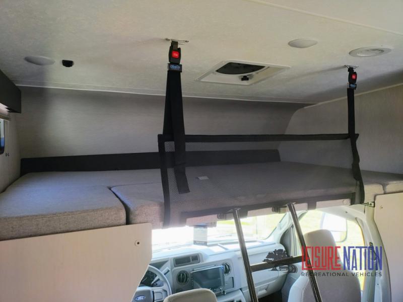 Spacious cab-over bunk in an RV rental, featuring a comfortable sleeping area with safety net and access ladder. Perfect for families.. Coachmen Freelander 2023