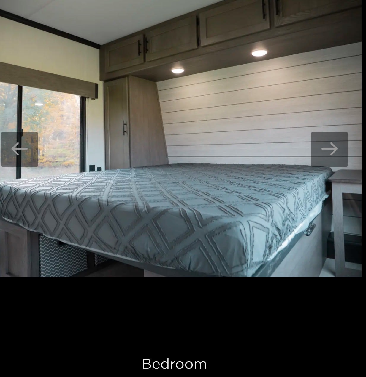 RV rental bedroom: cozy queen bed, overhead storage, and a large window view.. Forest River Cherokee Wolf Pack Toy Hauler 2025
