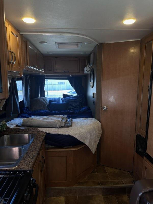 Step inside this cozy rv rental, featuring a compact kitchen, comfortable bedroom, and ample overhead storage.. Thor Four Winds 2017