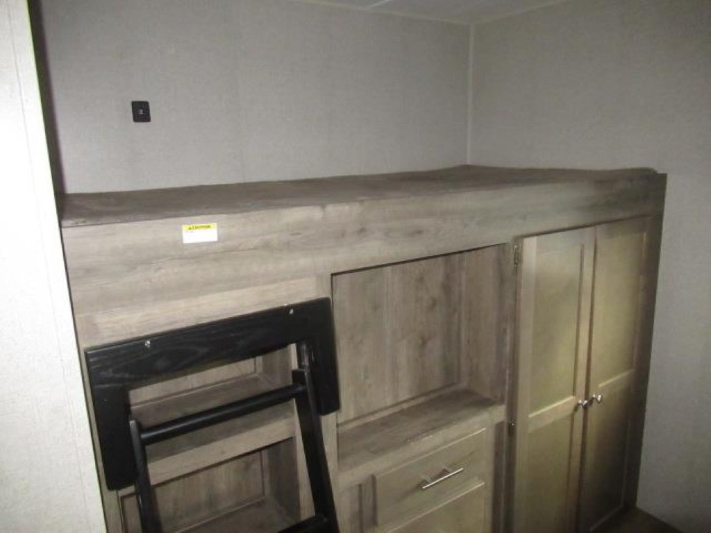 RV rental interior features a bunk bed with ladder, storage shelves, drawers, and a wardrobe, perfect for family adventures.. Dutchmen Aspen Trail 2019