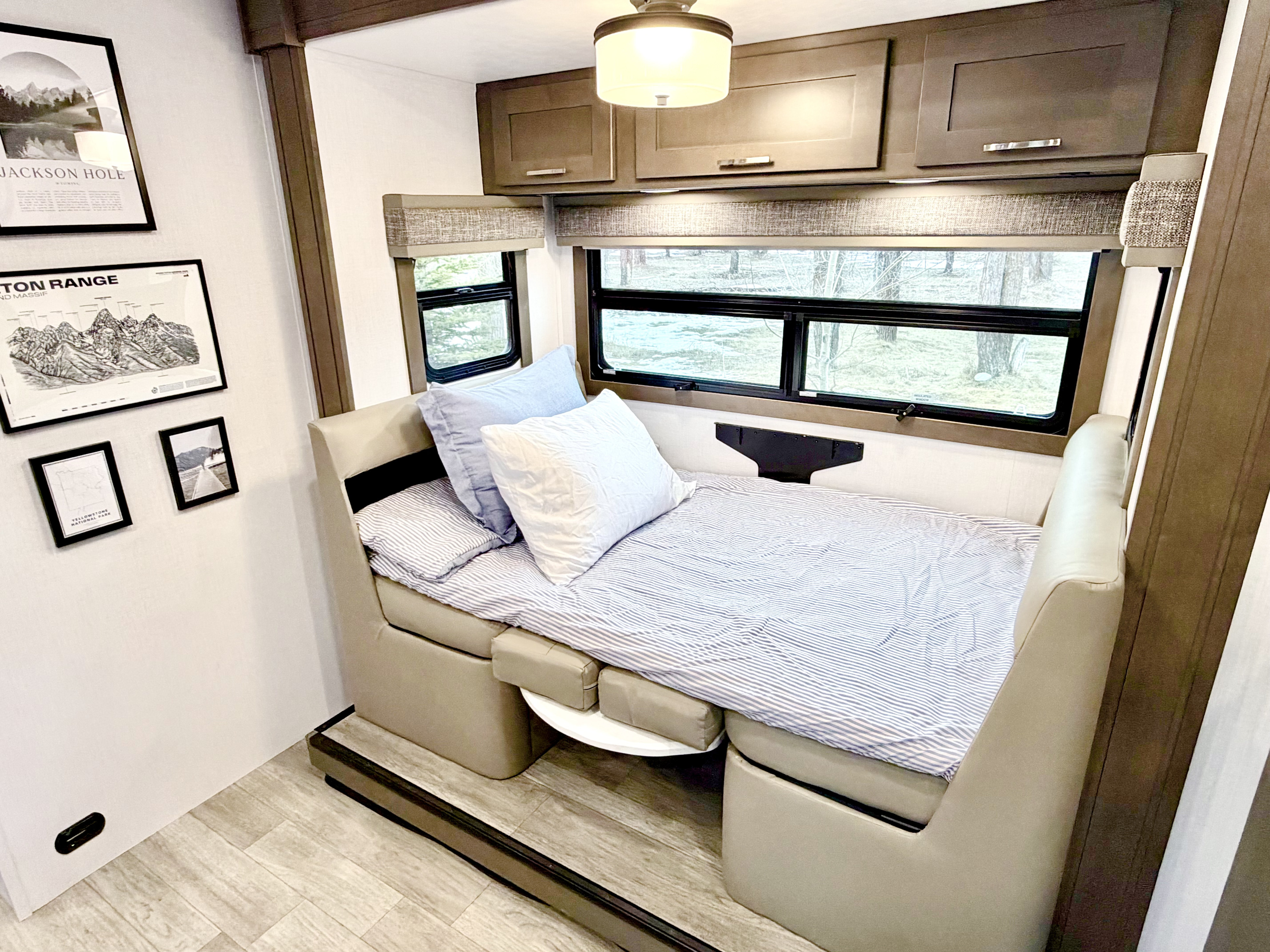 This RV rental's dinette easily converts into a cozy sleeper, offering windows with views, overhead storage, and stylish decor.. Dynamax Explore ISATA 5 Explorer Extreme Package 2026