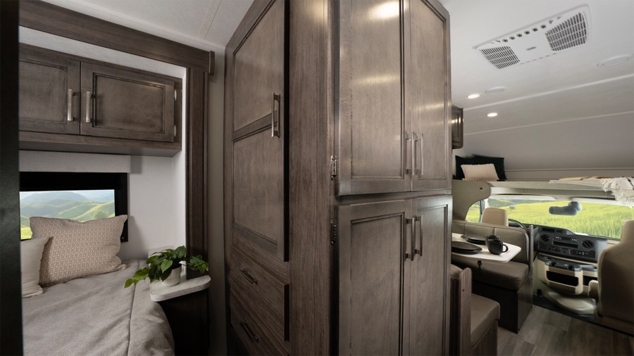 Spacious rv rental interior showcases modern storage, cozy bed, dining area, and front cabin with scenic views. Central AC visible.. Entegra Odyssey SE 2026