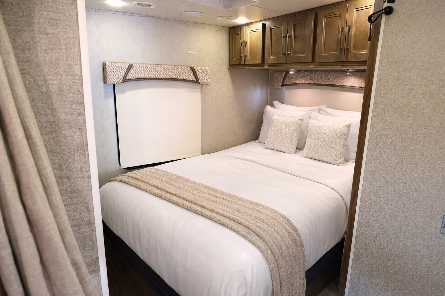 Cozy RV rental bedroom with white bedding, a neutral throw blanket, overhead cabinets, and a compact headboard for comfort.. Jayco Envoy 200 2018