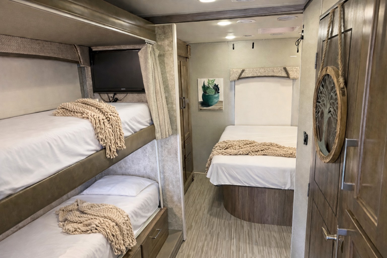 Explore this cozy rv rental bedroom with a comfy main bed, bunk beds, and a TV, ideal for a family getaway.. Jayco Envoy 200 2018