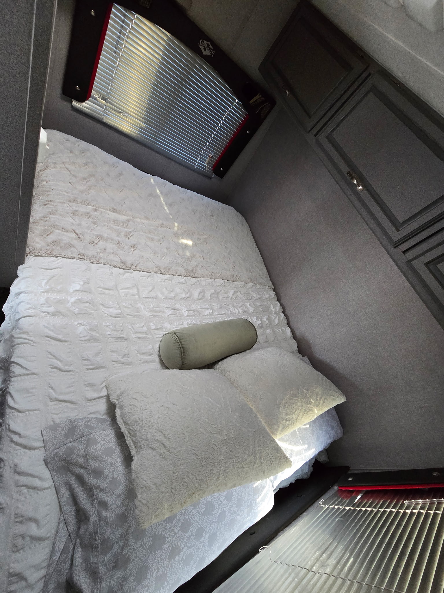 Experience comfort in this RV rental bedroom featuring a cozy bed with textured white bedding, window blinds, and storage.. Weekend Warrior Fs2300superlite 2007