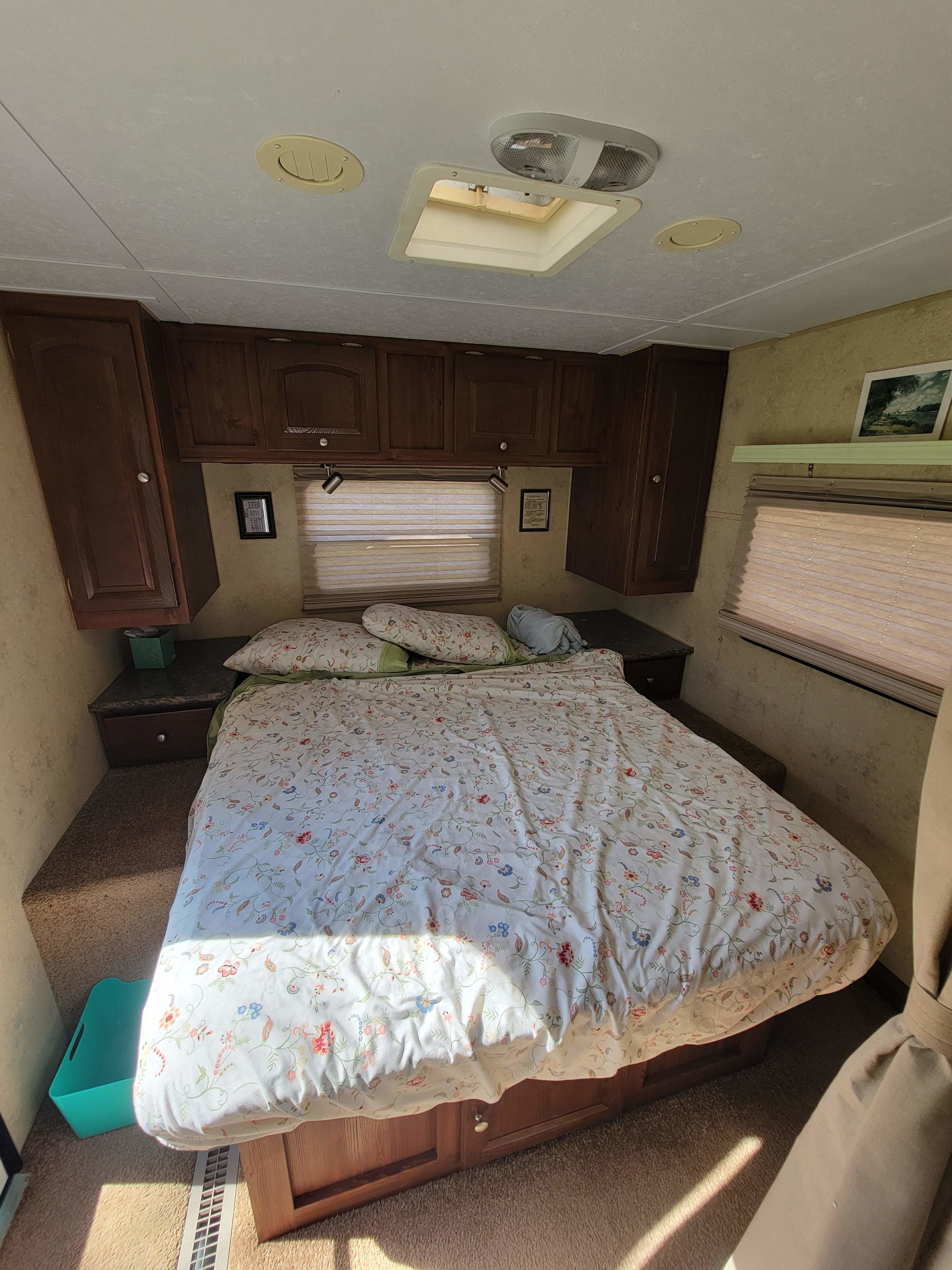 Cozy RV rental bedroom with a floral bed, built-in storage, and natural light, perfect for your next adventure.. Forest River Flagstaff V-Lite 2010