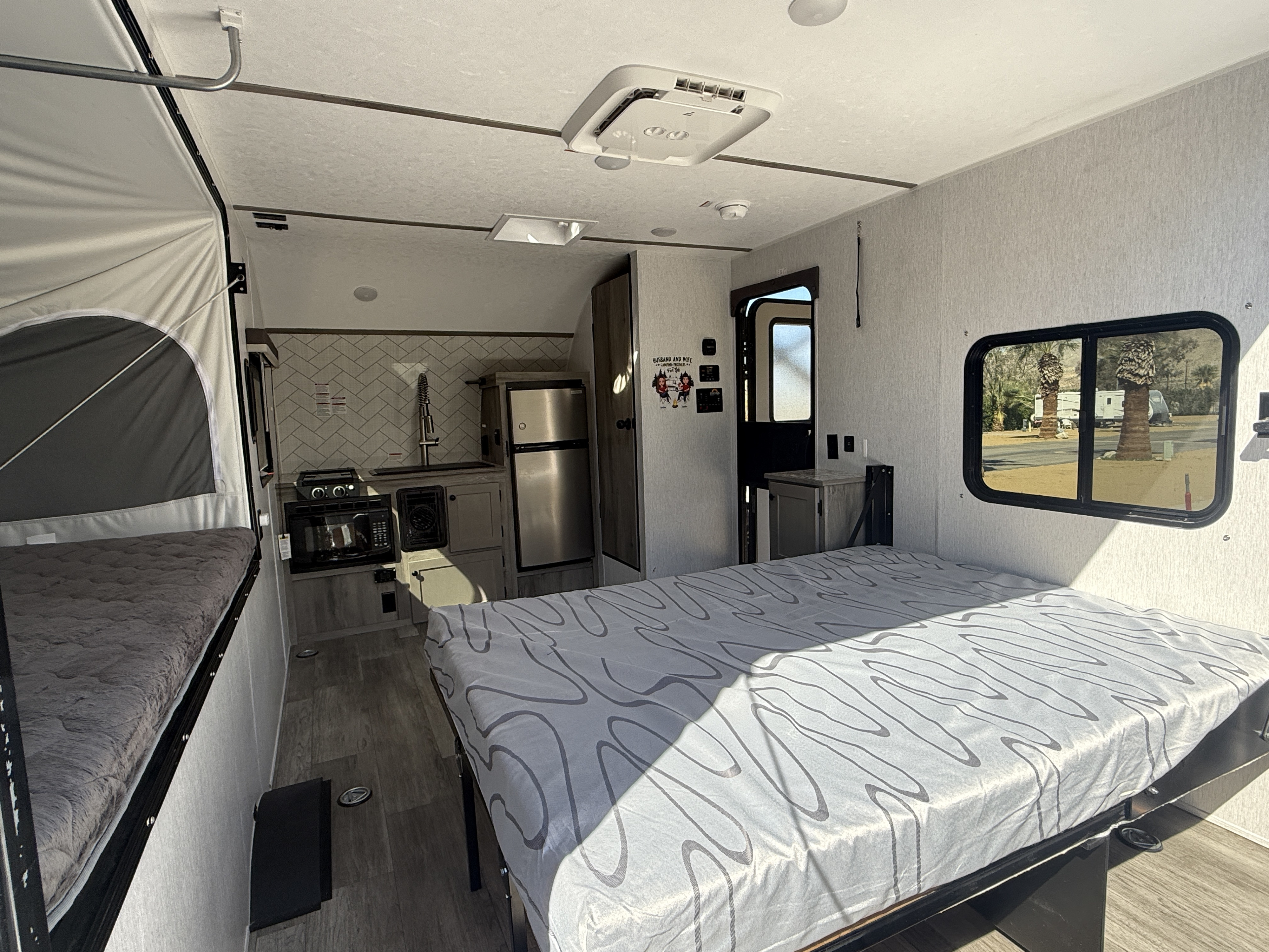 This RV rental interior features a kitchen, main bed, and pop-up bunk, offering a compact and functional living space.. Sun Lite 14 THX 2026
