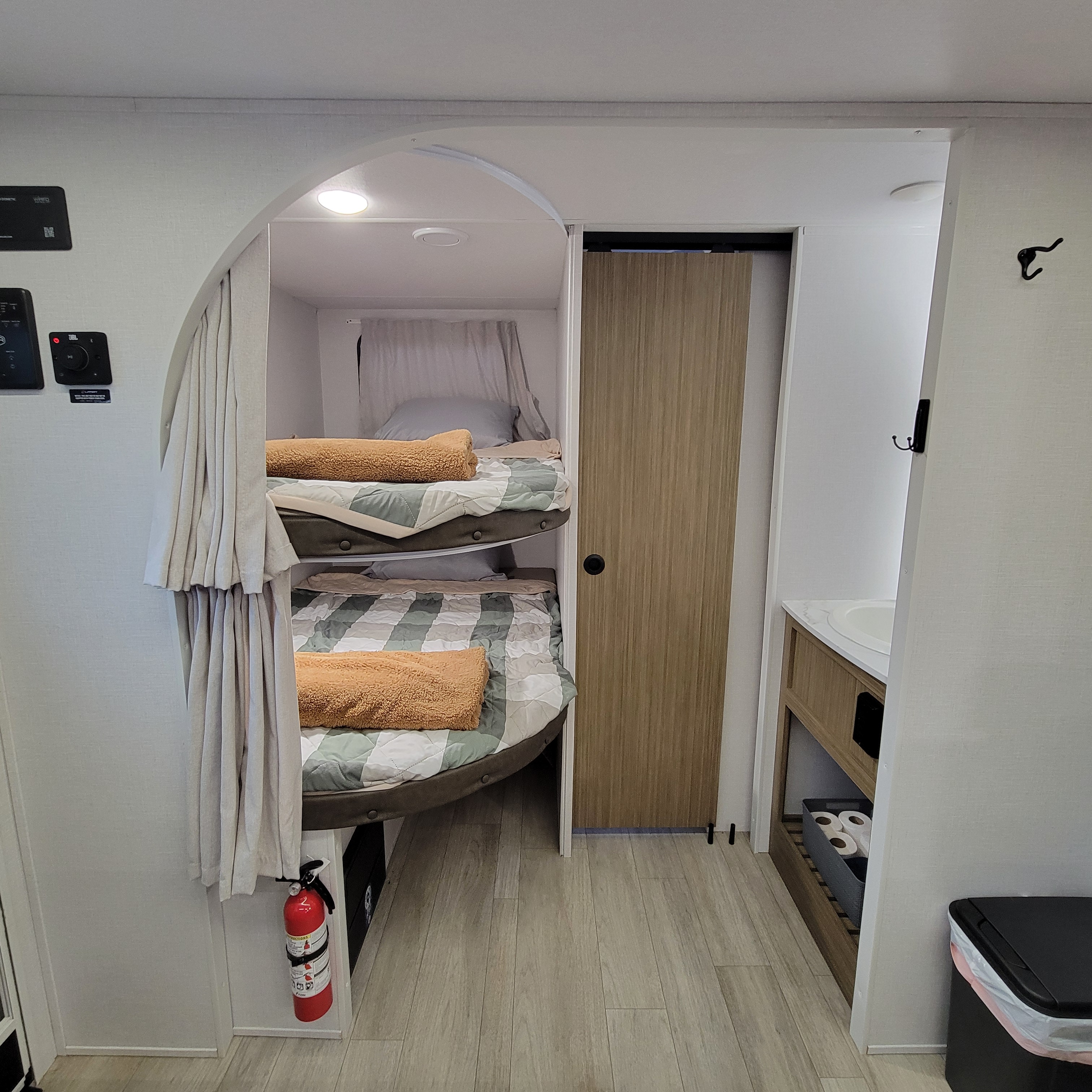 Inside an RV rental: a compact sleeping area with bunk beds, an adjacent small bathroom sink, and control panel on the wall.. Forest River Salem Cruise-Lite 2026