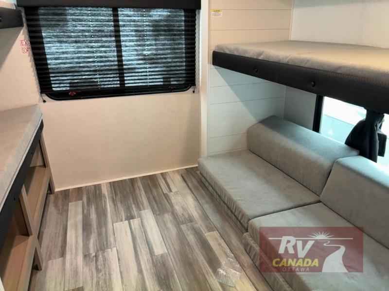 Modern RV rental interior featuring bunk beds, a sofa, and wood-look flooring for comfortable travel.. Jayco Jay Flight SLX TT 2026