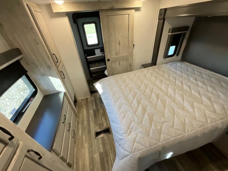 Explore this comfortable RV rental. Features a spacious bedroom with a queen bed, ample storage, and private bathroom access.. Keystone RV Avalanche 2022