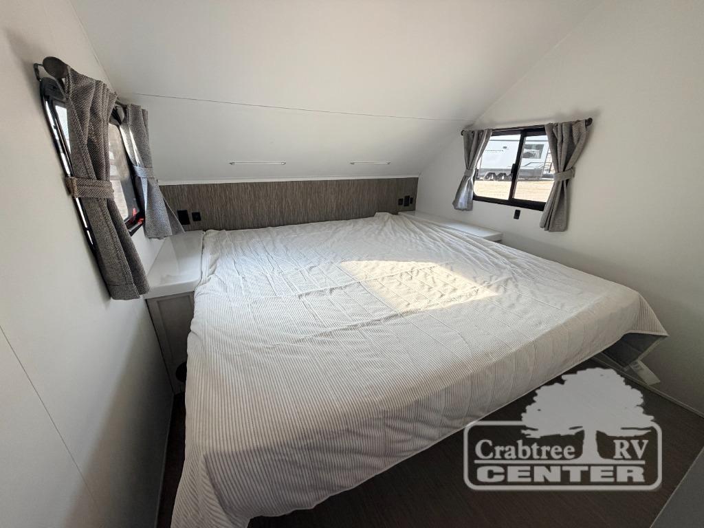 Spacious RV rental bedroom featuring a comfortable bed with windows and bedside storage, perfect for your travels.. Travel Lite Evoke 2020