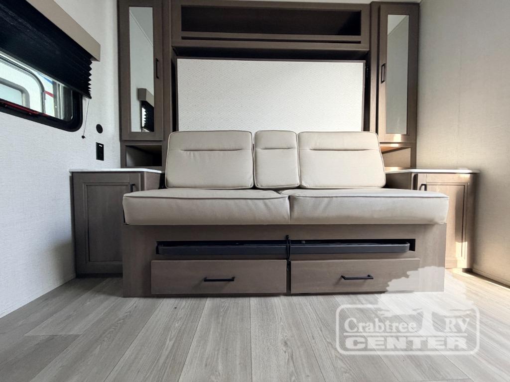 RV rental: Bright interior featuring a light-colored sofa, pull-out storage, and a convertible wall unit for comfort.. Grand Design Transcend One 2025
