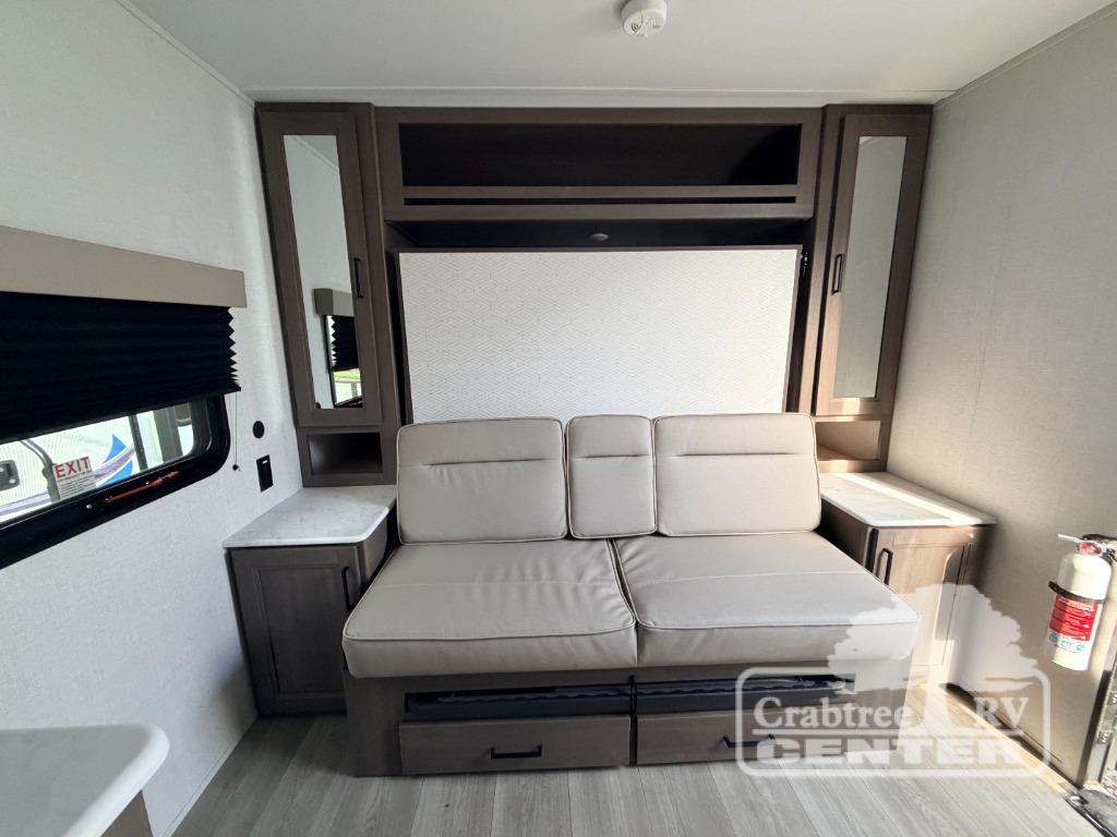 Spacious rv rental interior featuring a versatile sofa bed, overhead storage, side tables, and a window for comfortable travels.. Grand Design Transcend One 2025