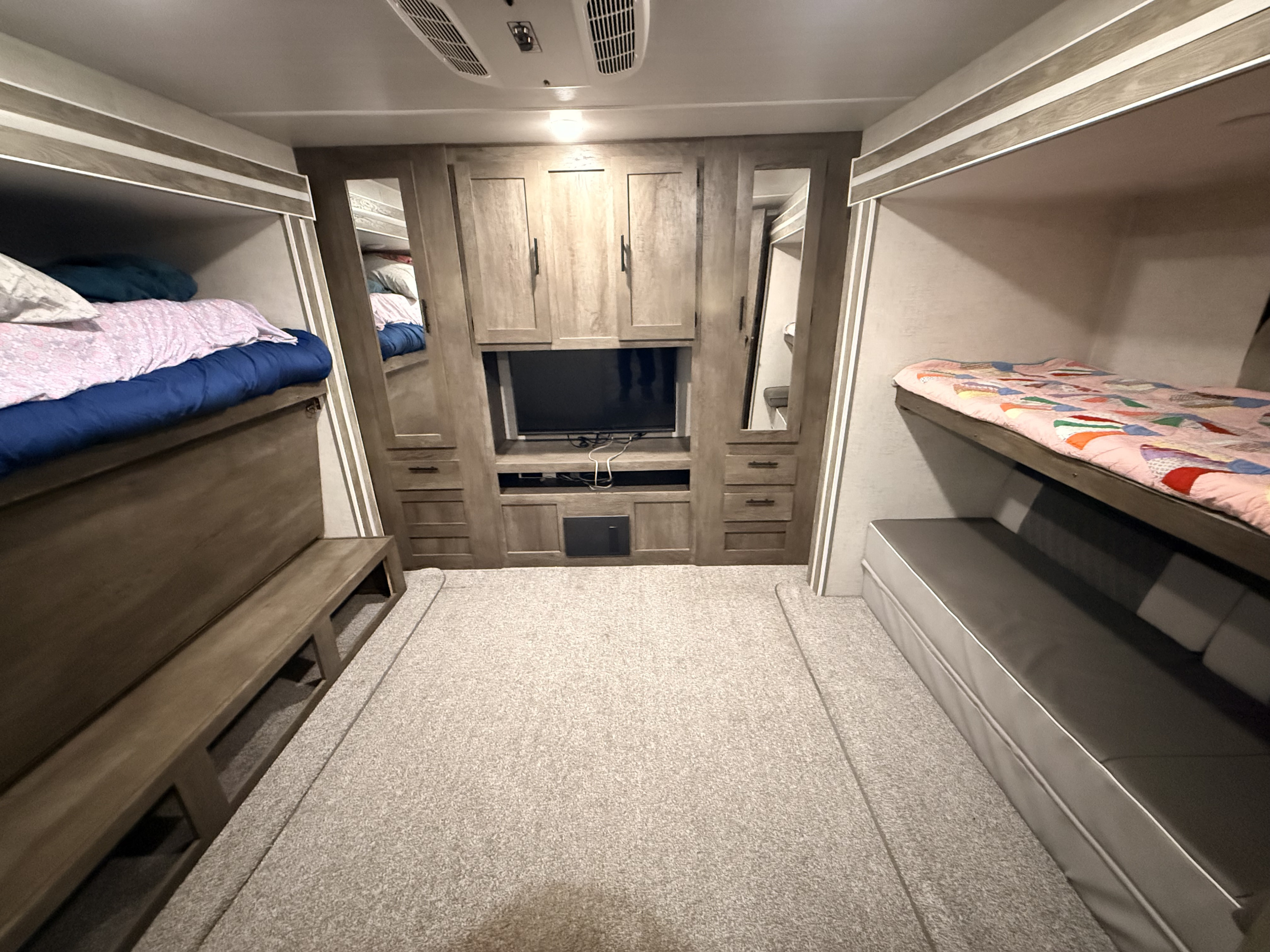 Cozy RV rental bunkhouse interior with bunk beds, TV, and storage. Ideal for family road trips.. Forest River Salem 2021