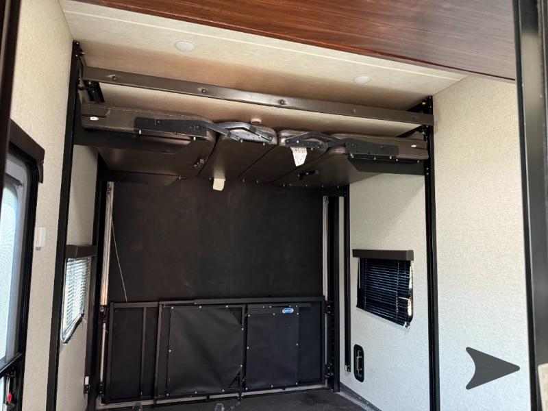 RV rental toy hauler garage. Upper bed system retracted, revealing versatile cargo or sleeping space with lower fold-down seating.. Heartland Torque 2017