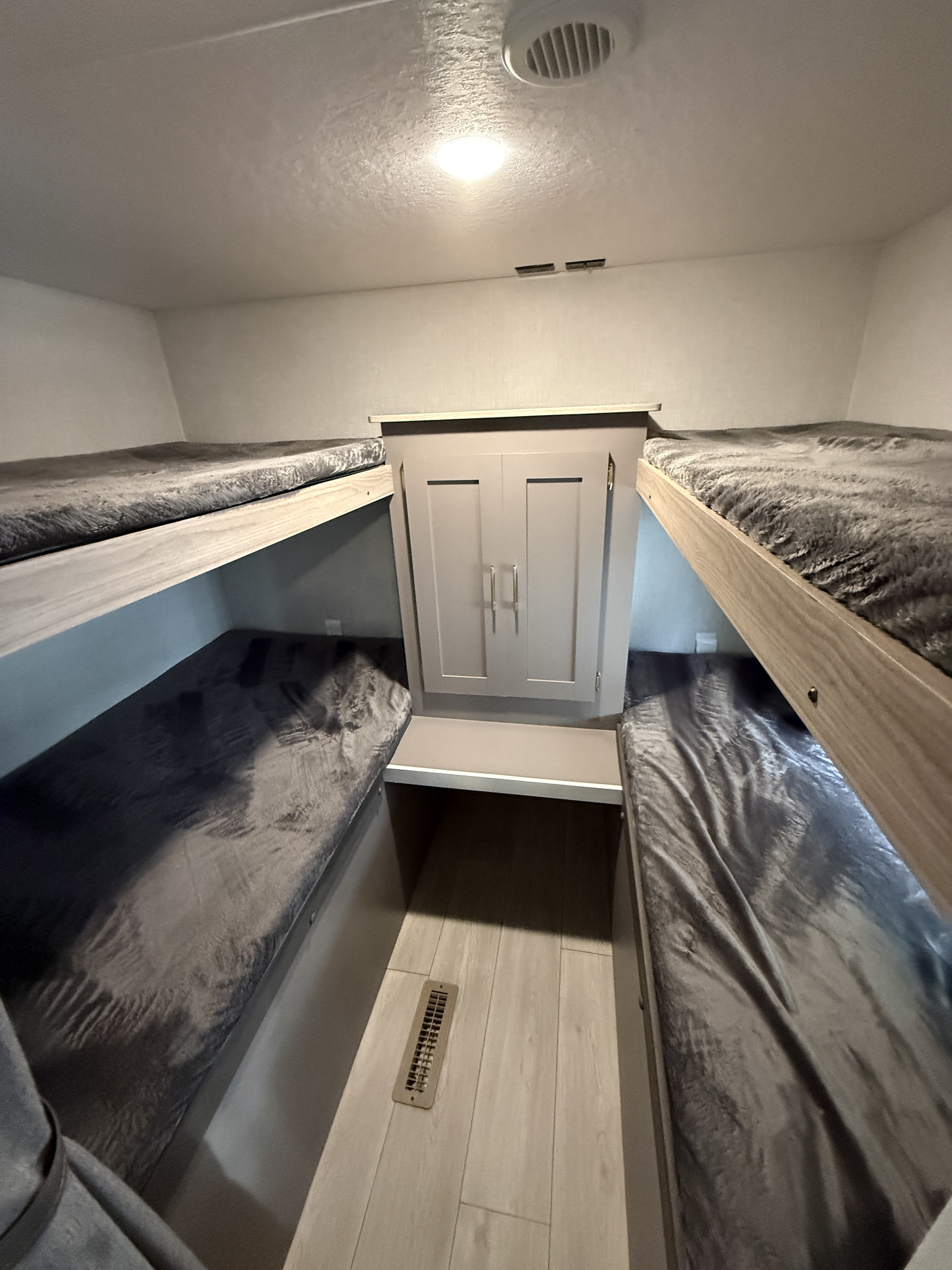 RV rental bunkhouse interior with four beds and central storage, perfect for families on a camping trip.. KZ Sportsmen SE 2025