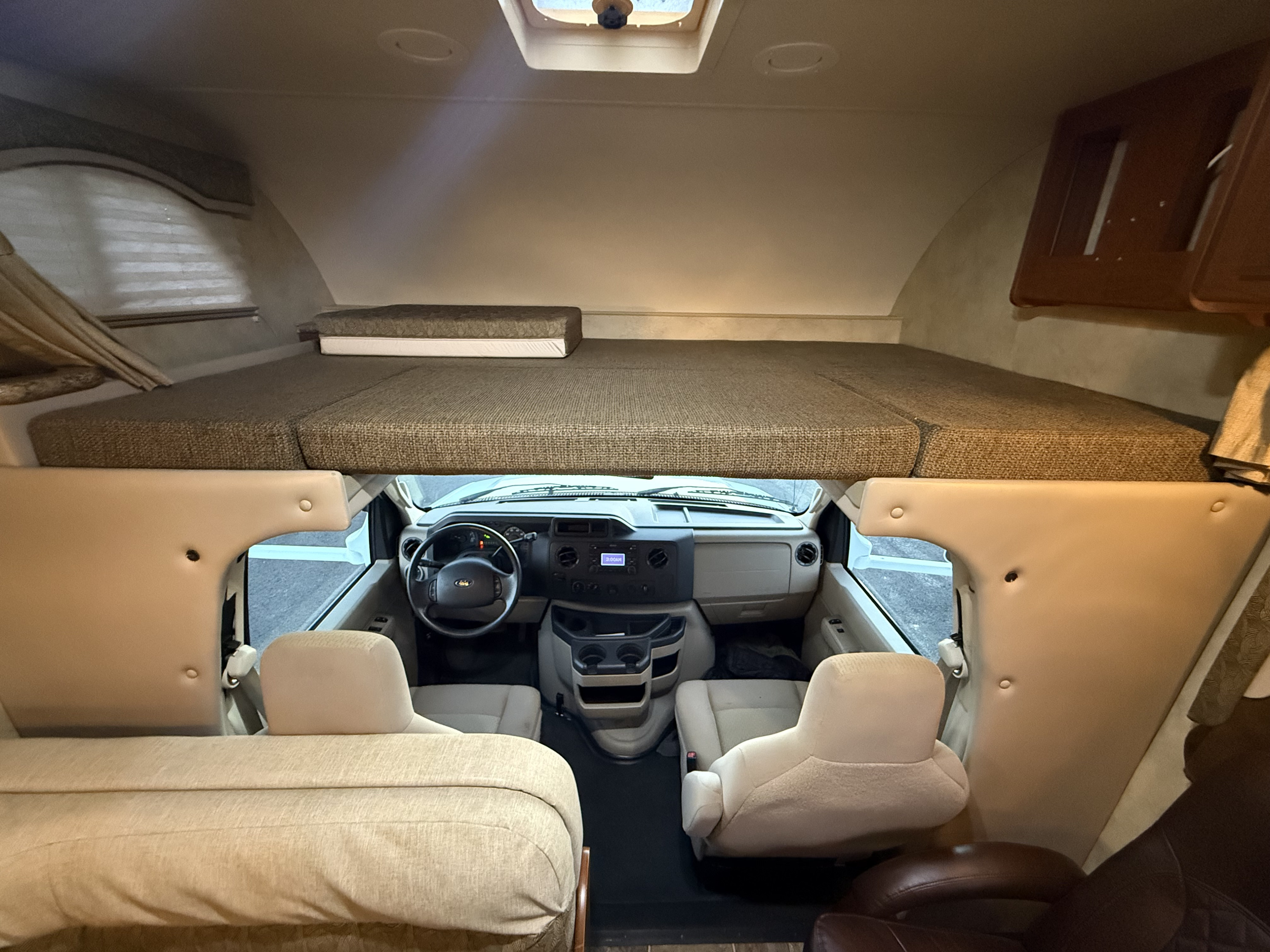 RV rental interior: A cozy cab-over bunk bed overlooks the driver's cockpit and front passenger seats.. Thor Freedom Elite 2012