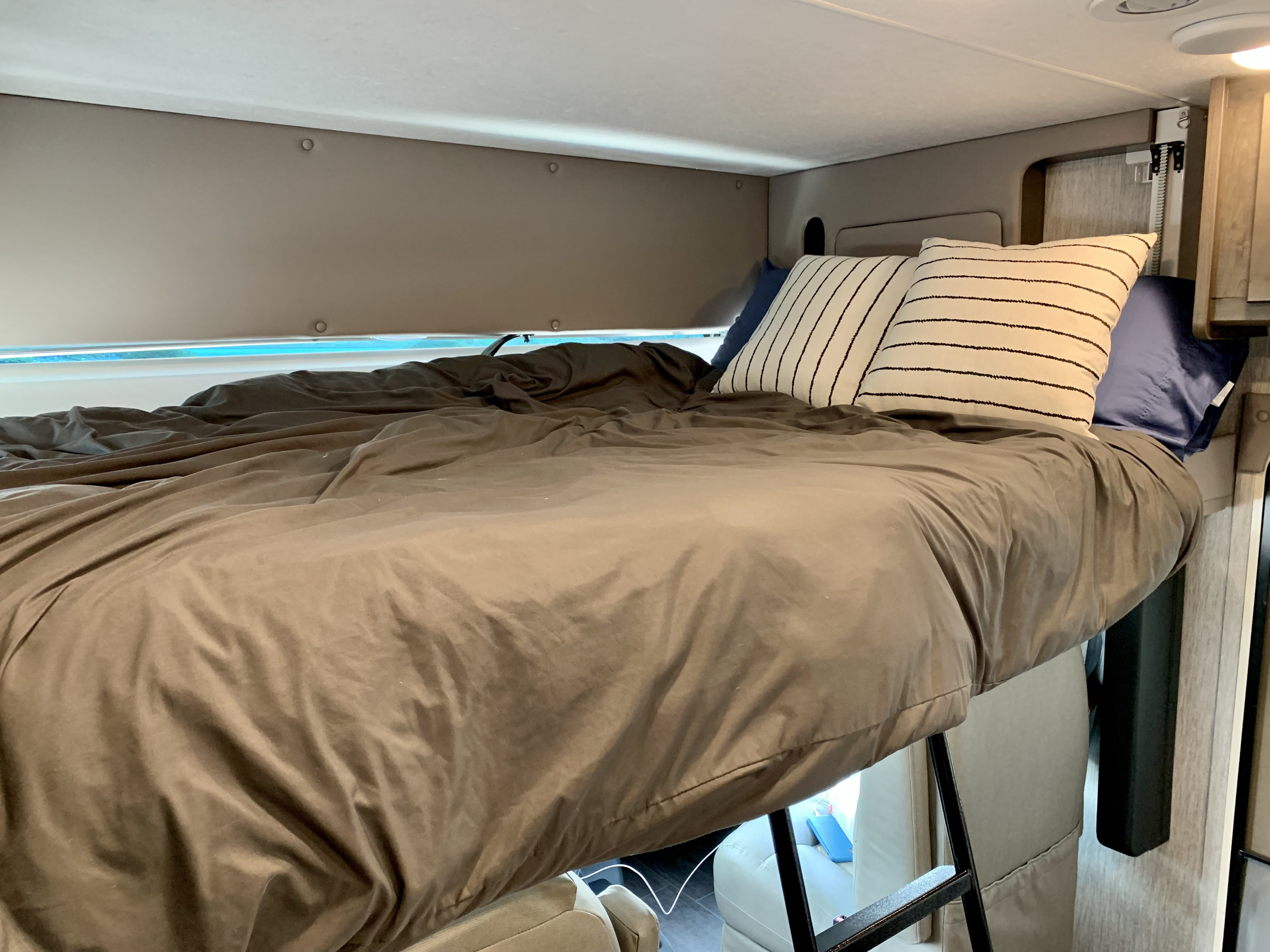 Cozy RV rental bunk bed with soft bedding and pillows, offering a comfortable sleeping space for your adventures.. Forest River Coachmen Mirada 2022