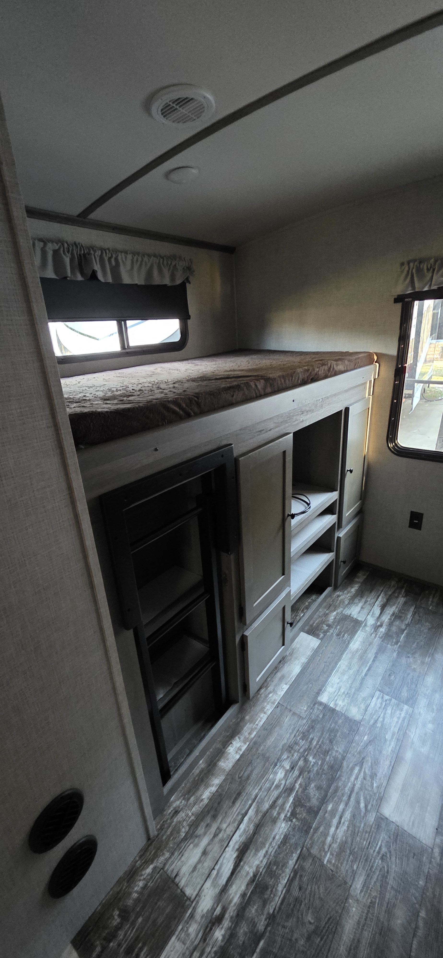 RV rental bunk bed with comfortable mattress, integrated storage, ladder, and windows, all on wood-look flooring.. Keystone RV Keystone Outback 340bh 2020
