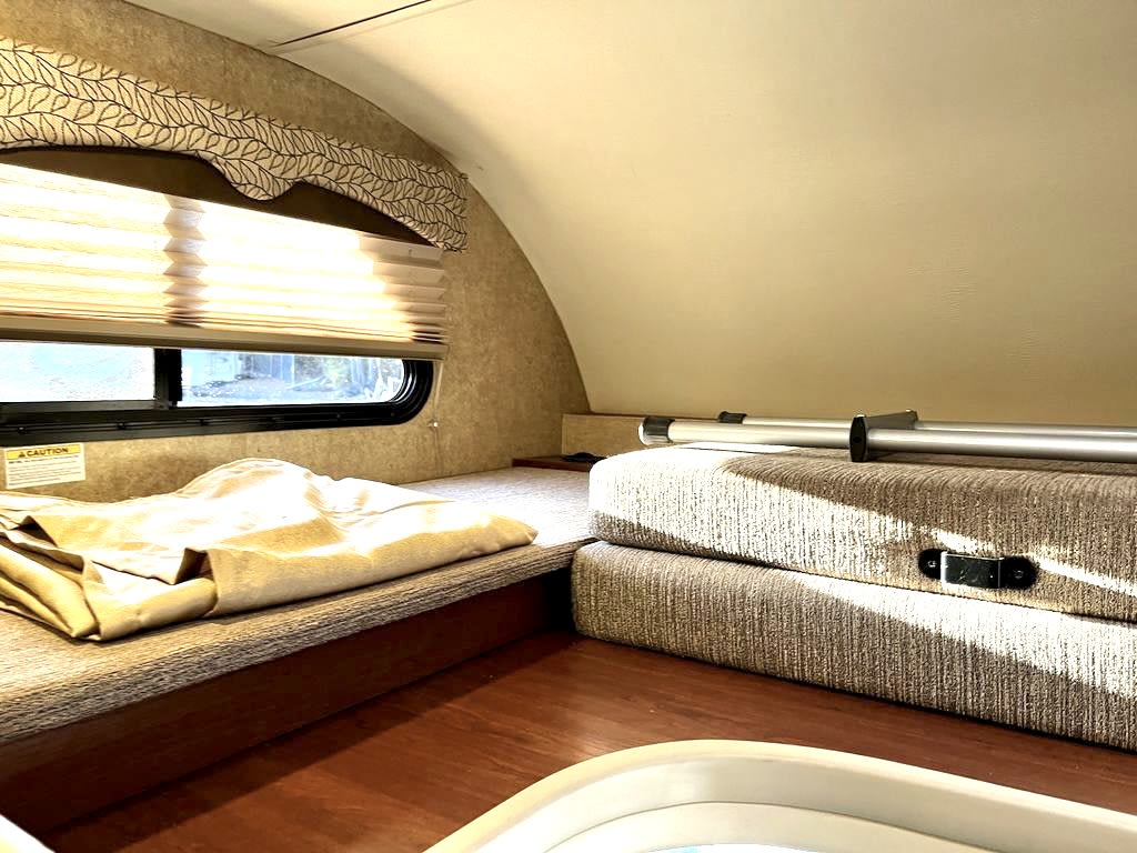 Experience comfort in this RV rental! Features a sleeping bunk with a window and blinds, plus versatile folded cushions.. Thor Freedom Elite 2017