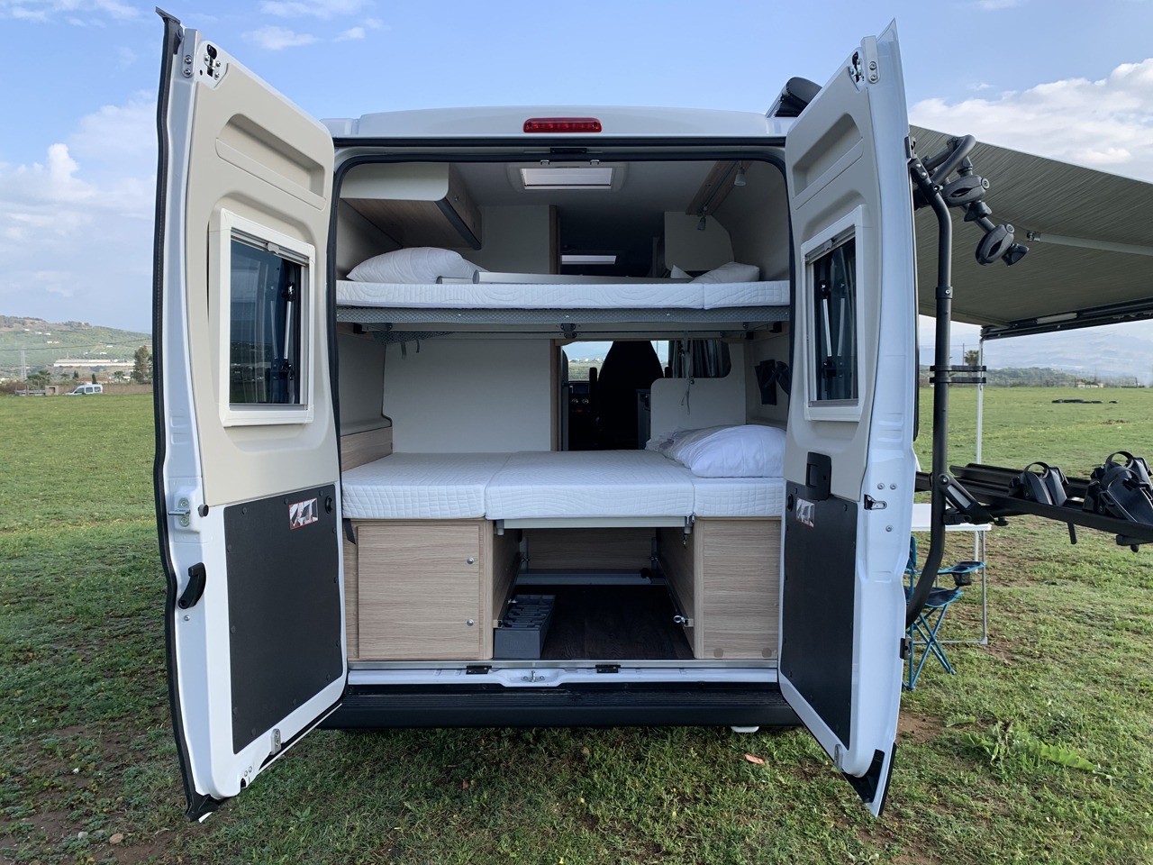 Explore this spacious **rv rental** with bunk beds! Rear doors open to reveal a comfortable interior, bike rack, and extended awning.. Sunlight Cliff 600 2023