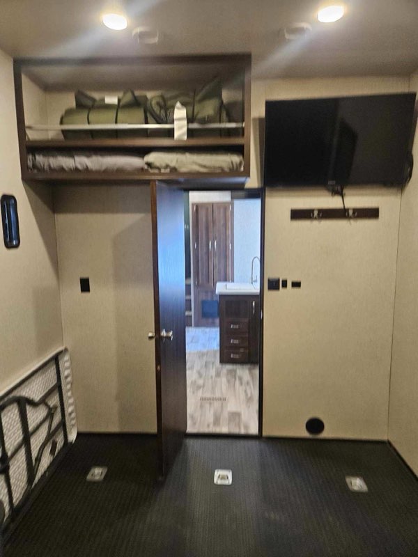 RV rental interior featuring a loft bed, TV, durable floor, and versatile storage for a functional travel space.. Jayco Talon 2018