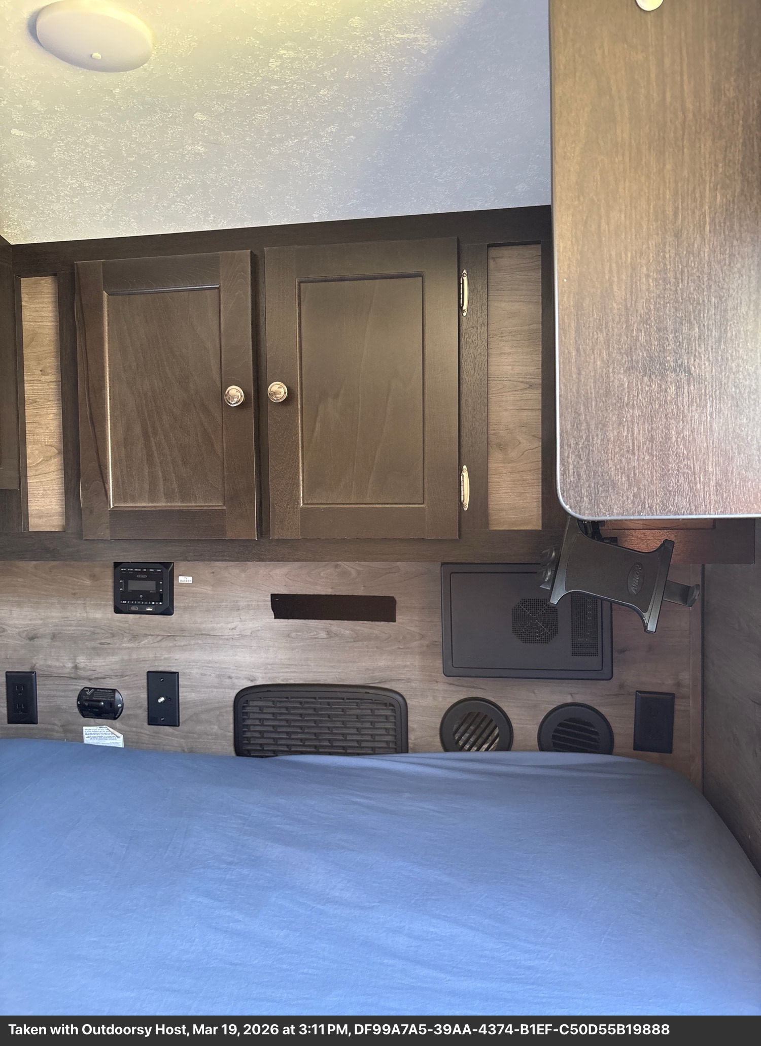 Modern RV rental sleeping area with convenient amenities: bed, cabinets, and power outlets.. Braxton Creek Free Solo 2022