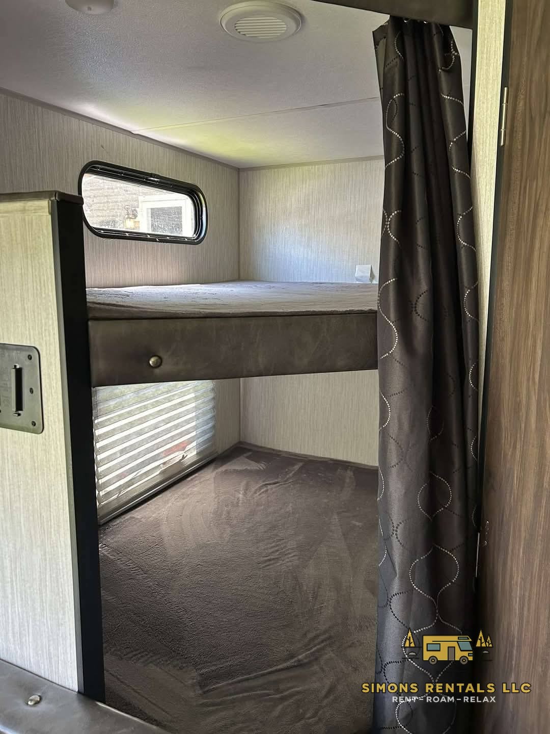 Cozy bunk beds in this RV rental, offering two sleeping levels, windows for natural light, and a privacy curtain.. Forest River Cherokee Grey Wolf Special Edition 2020