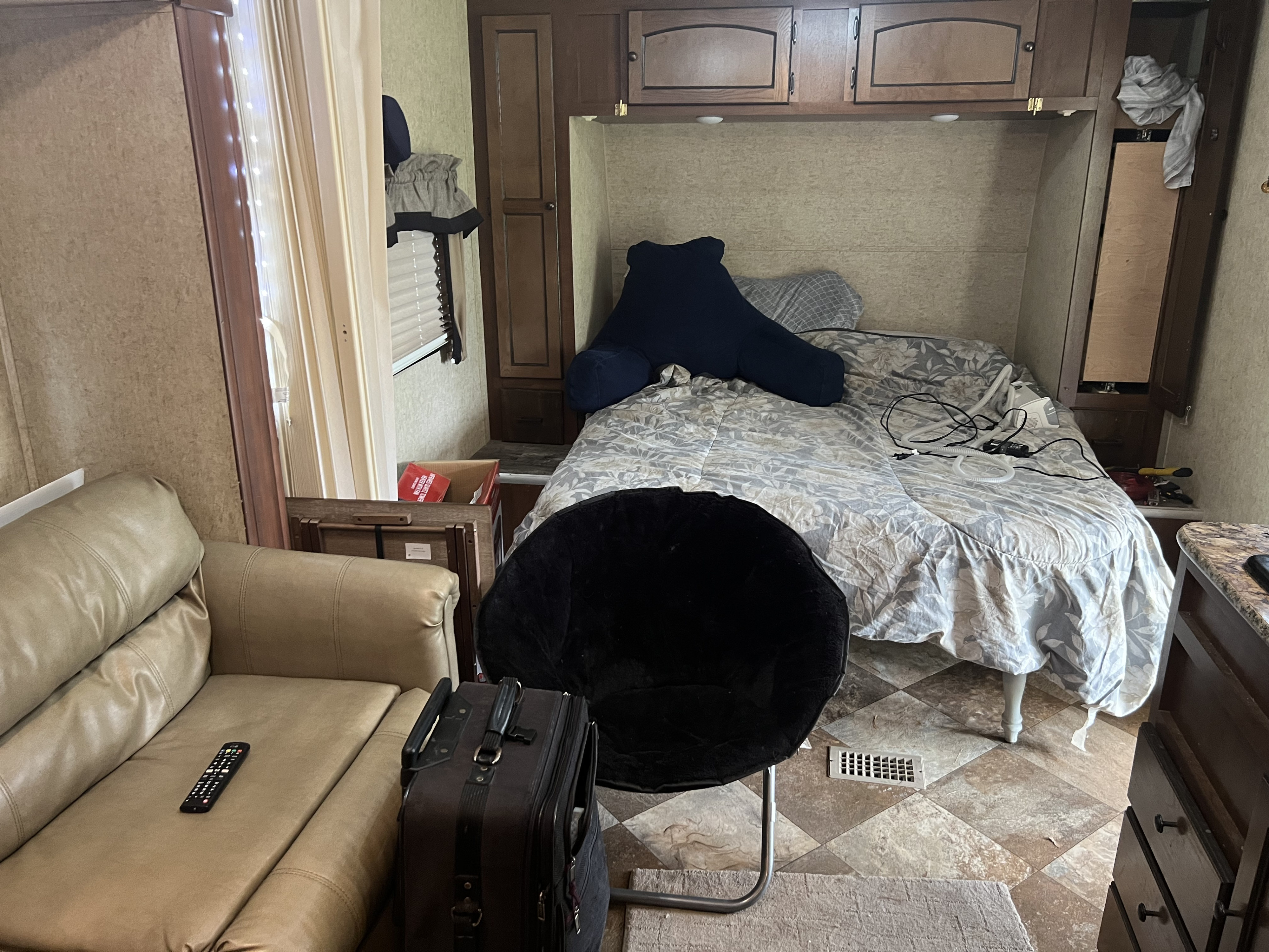 Inside an RV rental: a bed with CPAP, a comfy sofa with remote, and organized storage for your journey.. Nomad Nomad Trailer 2015