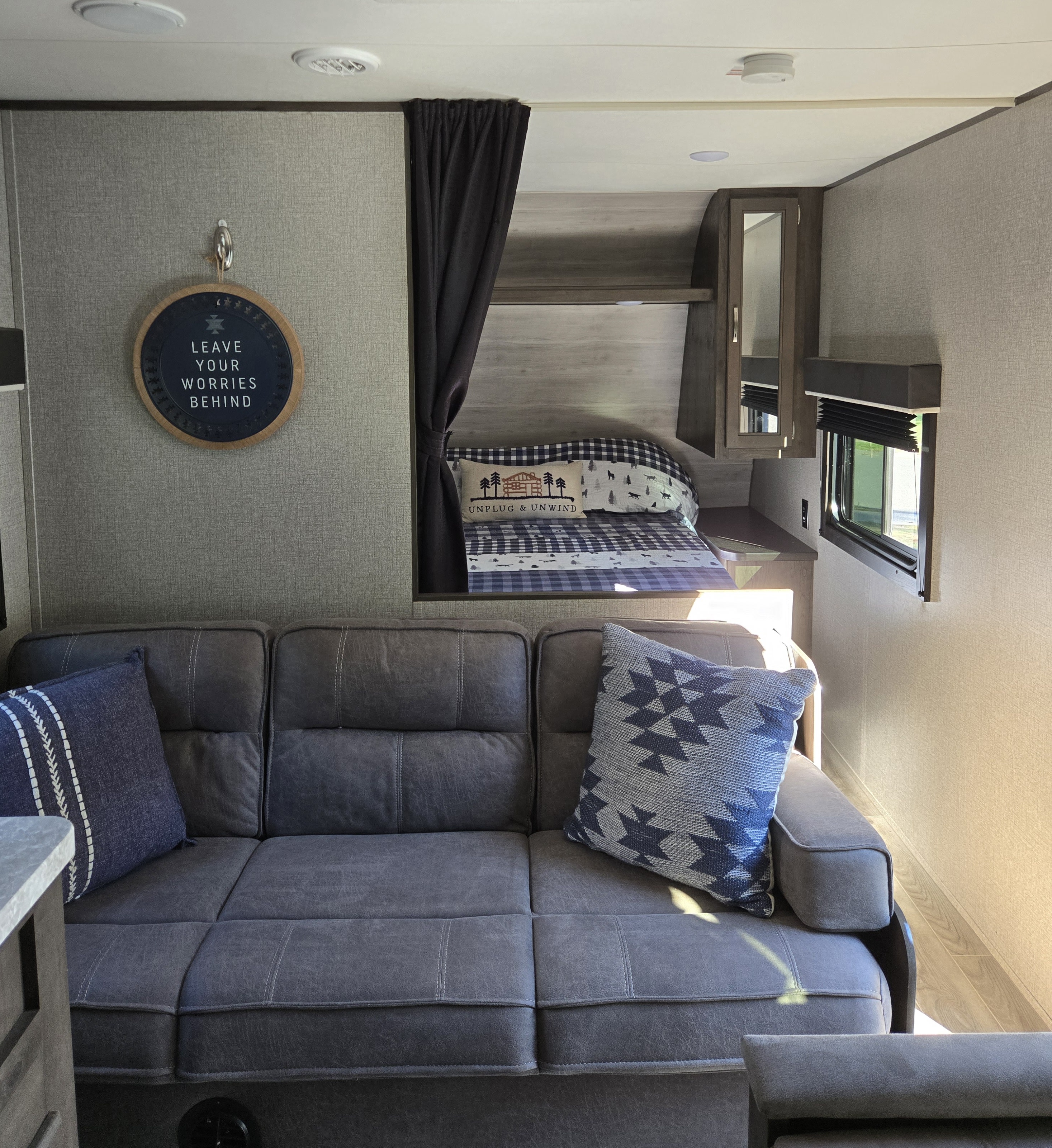 Cozy RV rental interior with a gray sofa, bunk bed, window, and inspirational decor. Perfect for travel adventures.. Jayco Jay Flight SLX 2021