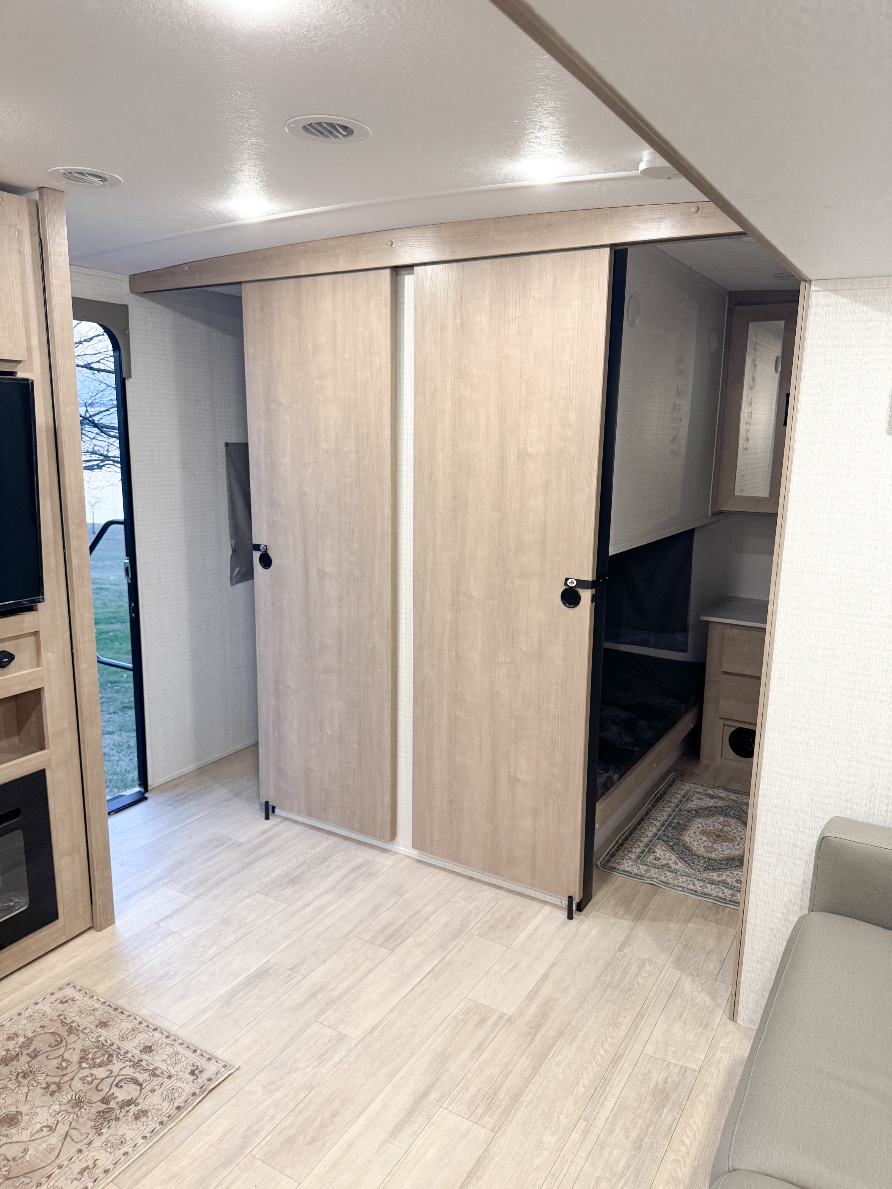 RV rental: Bright interior featuring light wood sliding doors to bunk beds, light flooring, and cozy seating.. Forest River Palomino Solaire 2025