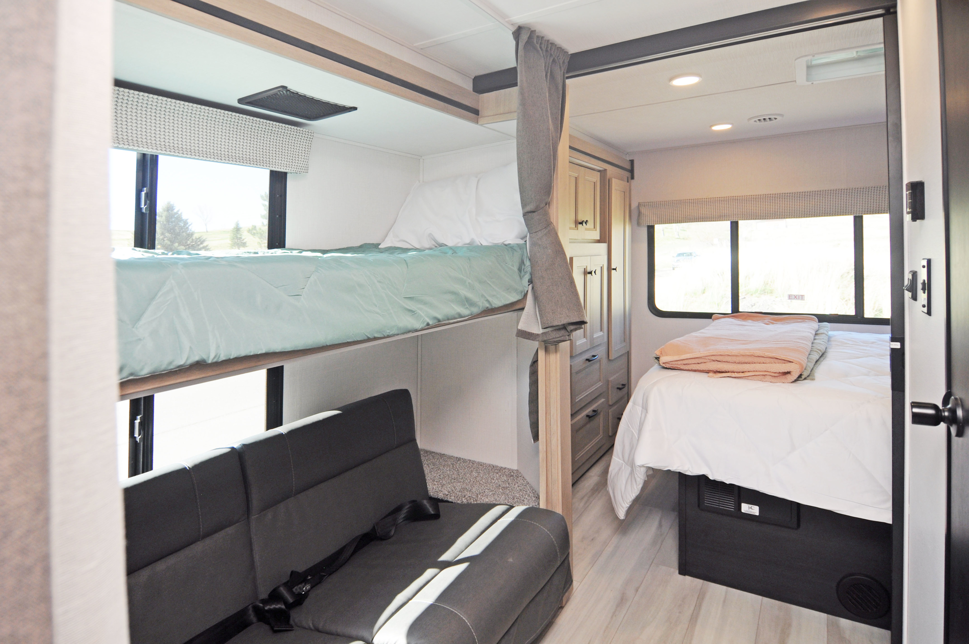 Comfortable RV rental interior with bunk beds, sofa, and main bed, perfect for a family camper trip.. Forest River Sunseeker LE 2025