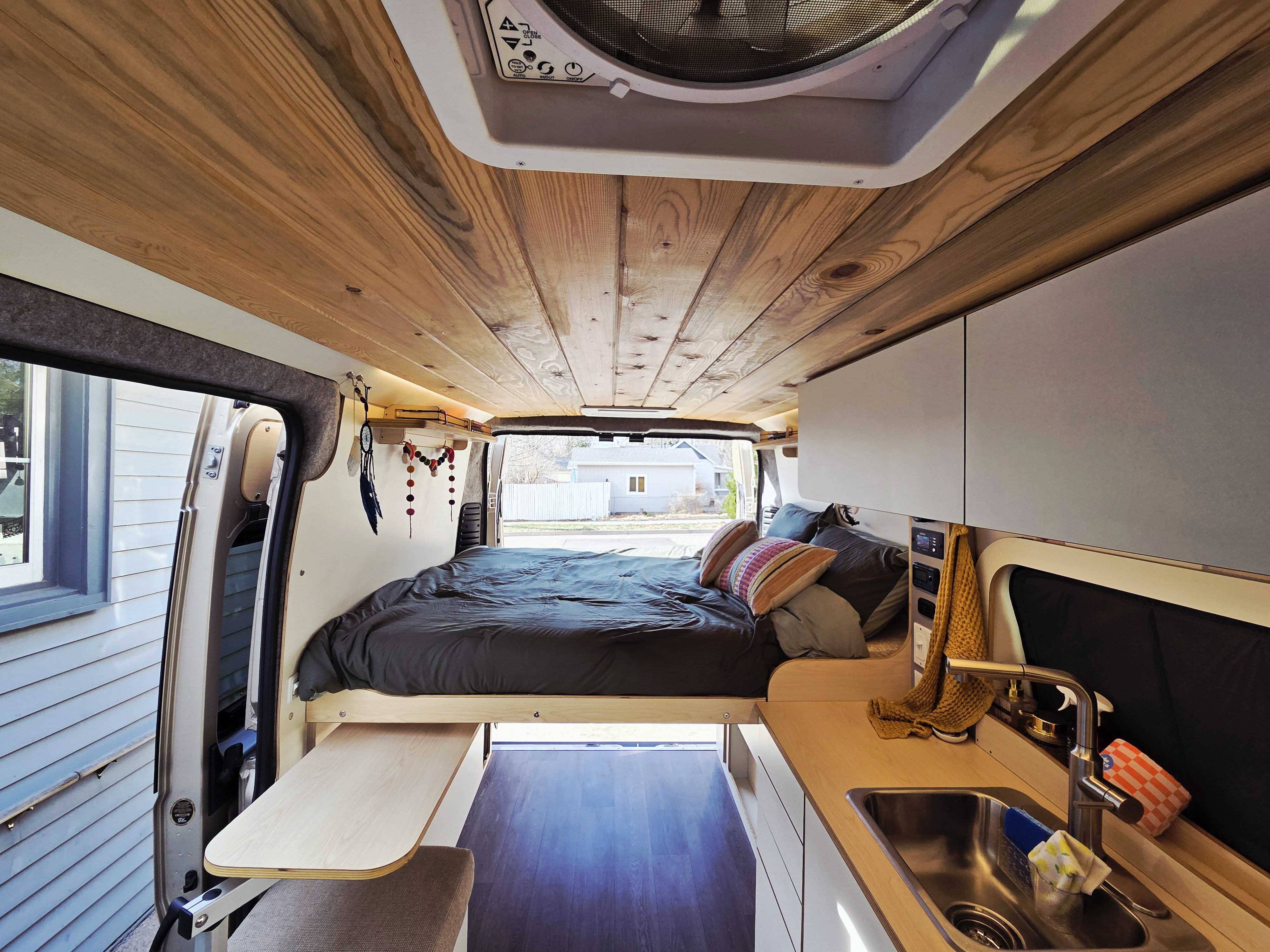 Discover cozy van life in this rv rental. Features a stylish wood-paneled ceiling, comfy bed, and compact kitchenette.. Dave & Matt Vans Dave & Matt Vans Class B 2024