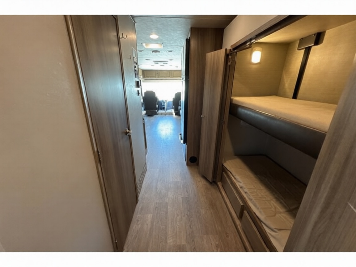 RV rental interior: a compact hallway featuring bunk beds on the right and the driver's area visible ahead.. Jayco Precept 2017
