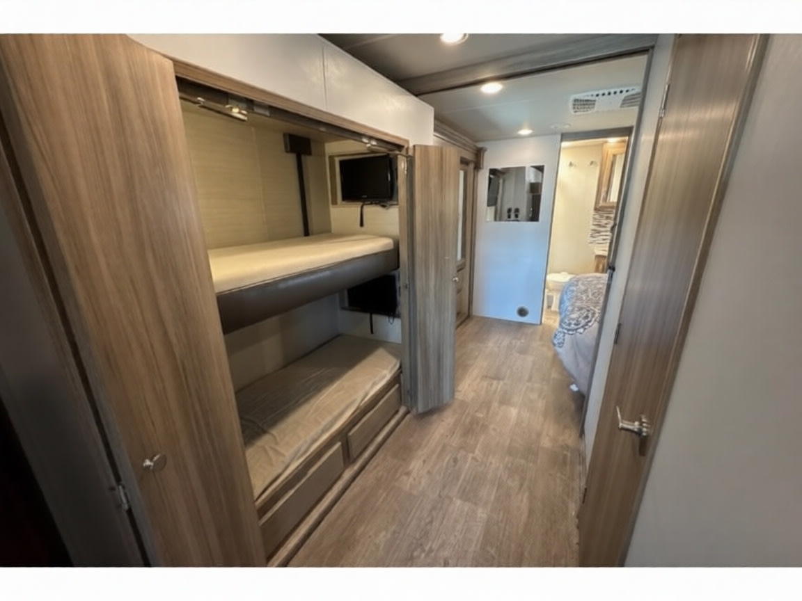 Inside this RV rental: Bunk beds, individual TVs, and a modern hallway leading to the bedroom area.. Jayco Precept 2017