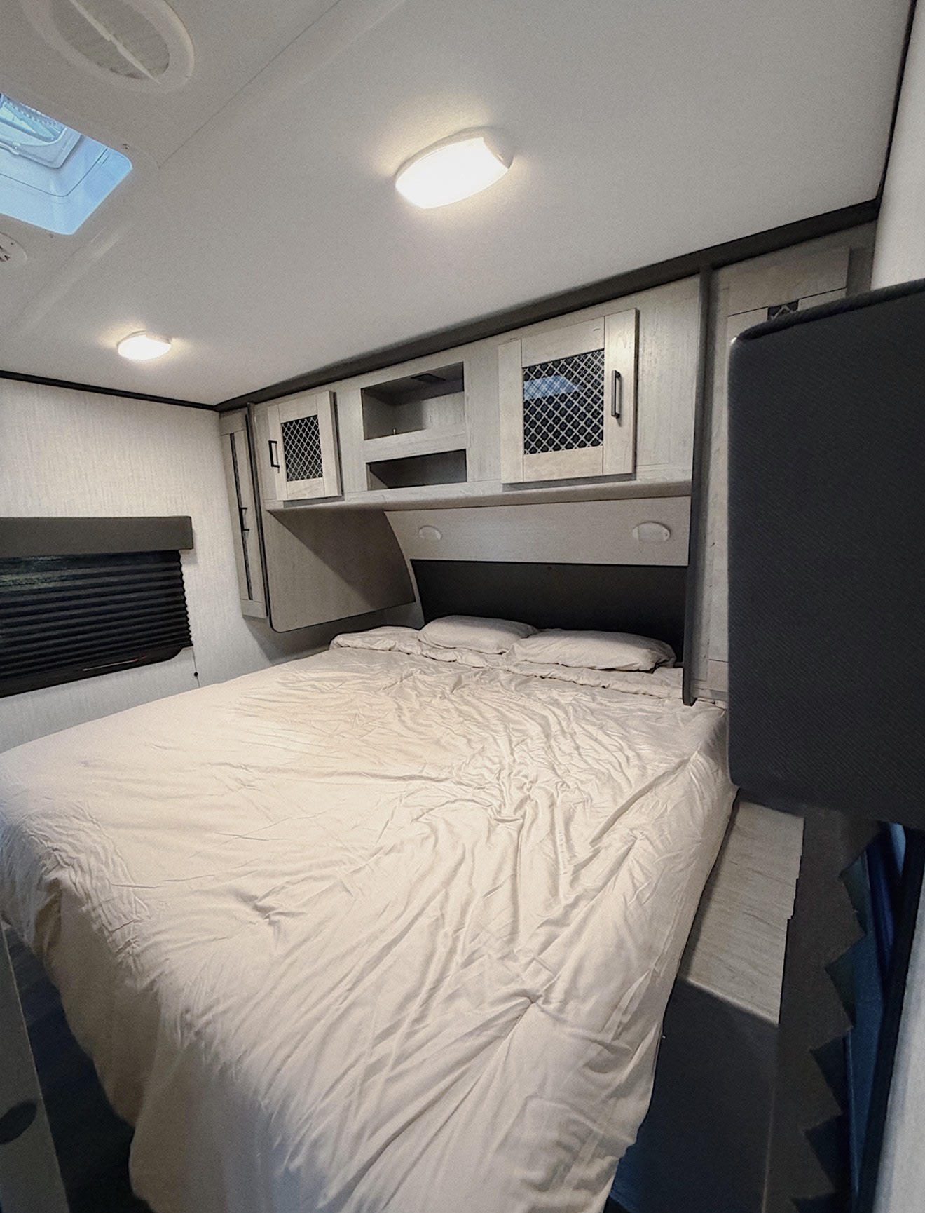 Cozy rv rental bedroom featuring a comfy bed, overhead storage cabinets, and a window with blinds, ready for your travels.. Heartland RVs Mallard 2021