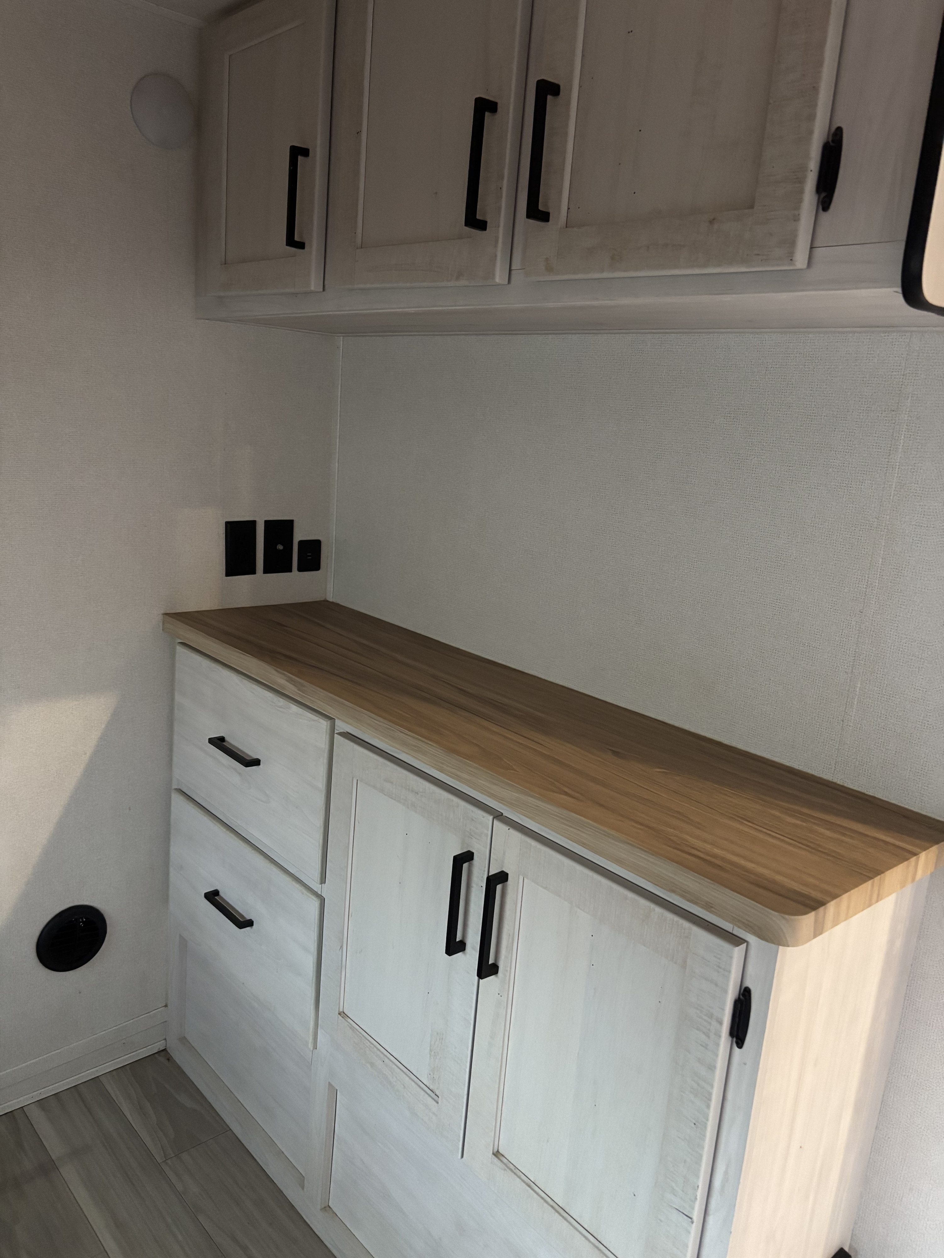 Modern RV rental interior with light wood cabinets, countertop, and wall outlets including USB ports, offering ample storage.. Crusader Crusader Fifth Wheel 2023