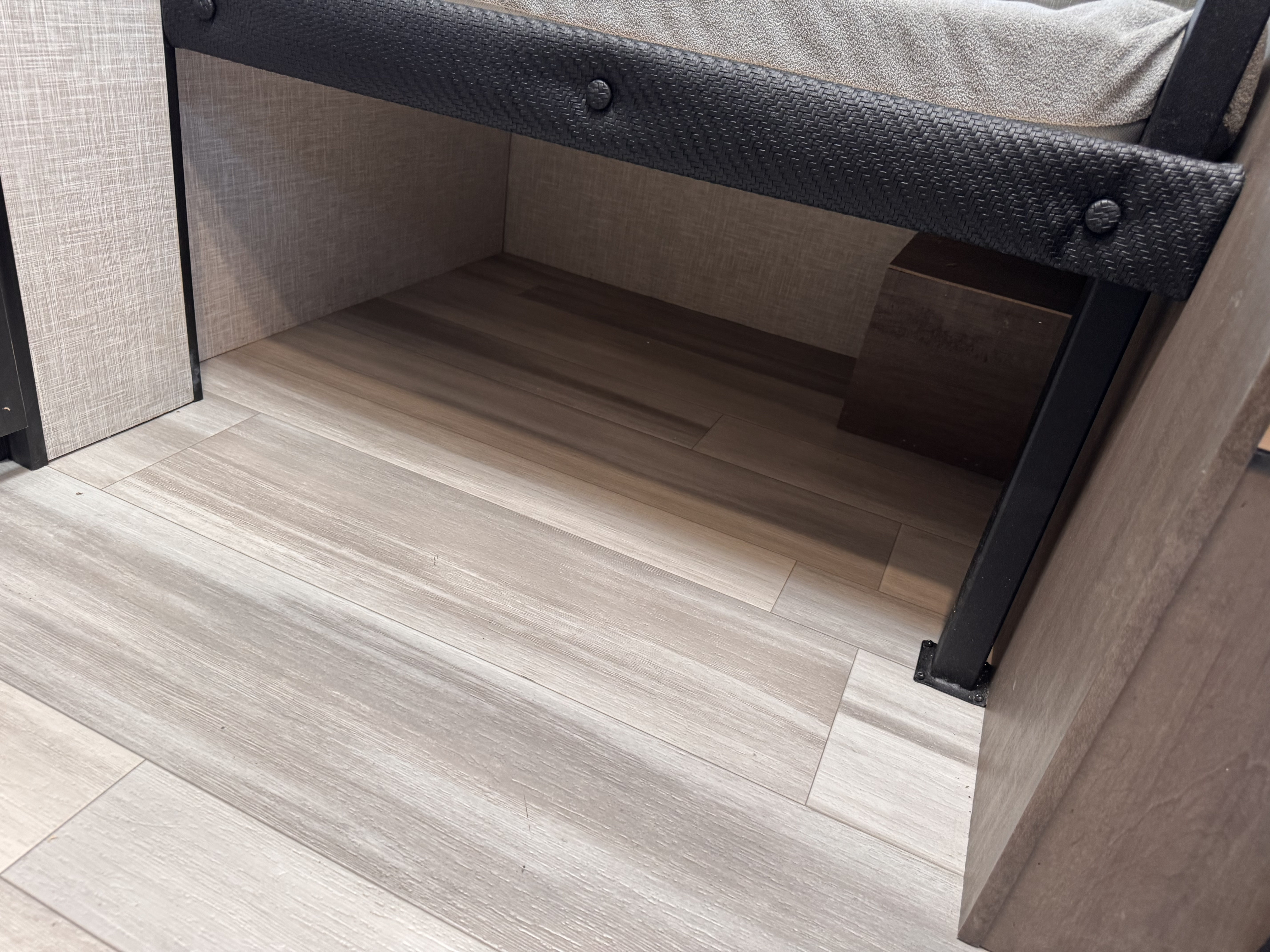 Under-bed storage in an rv rental, featuring light wood-look flooring and textured wall panels.. Starcraft Autumn Ridge 2026
