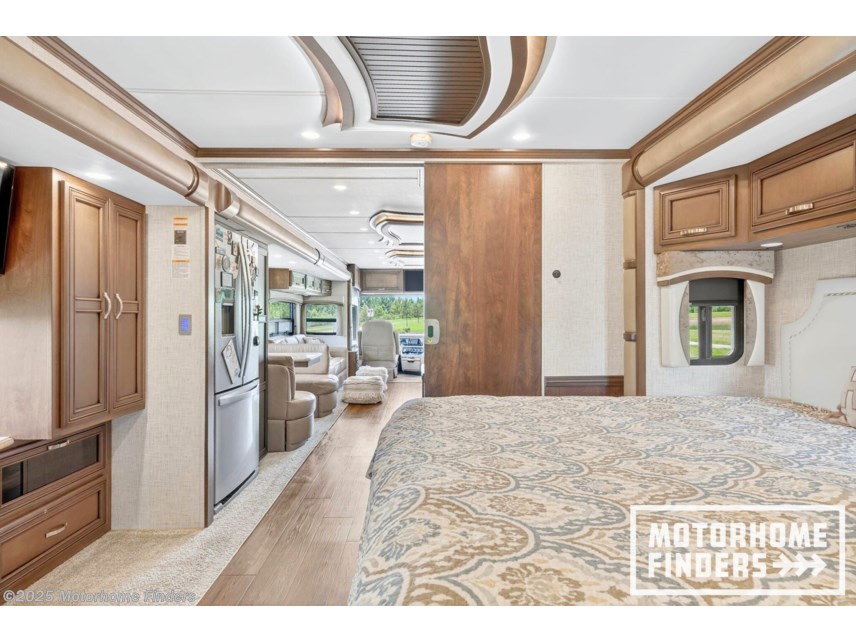 Explore this luxurious RV rental interior, featuring a spacious bedroom, full kitchen, and comfortable living area with booth seating.. Kountry Star Kountry Star Motorhome 2021