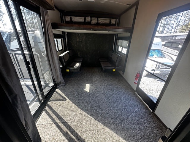 Inside an rv rental toy hauler: a versatile garage space with an upper bunk, foldable seating, and rear ramp for easy access.. Heartland RVs Torque Toy Hauler 2019