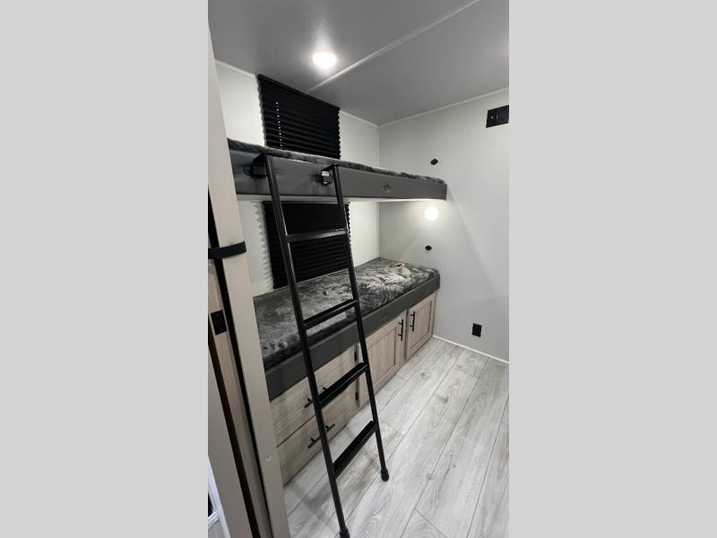 Cozy RV rental bunk beds with ladder and built-in storage cabinets. Ideal sleeping area for your next camper adventure.. Della Terra 250QB 2026
