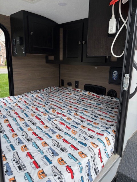 Cozy RV rental interior featuring a car-themed bed, overhead storage, and charging ports, ready for your next travel adventure.. Braxton Creek Bushwhacker 2024