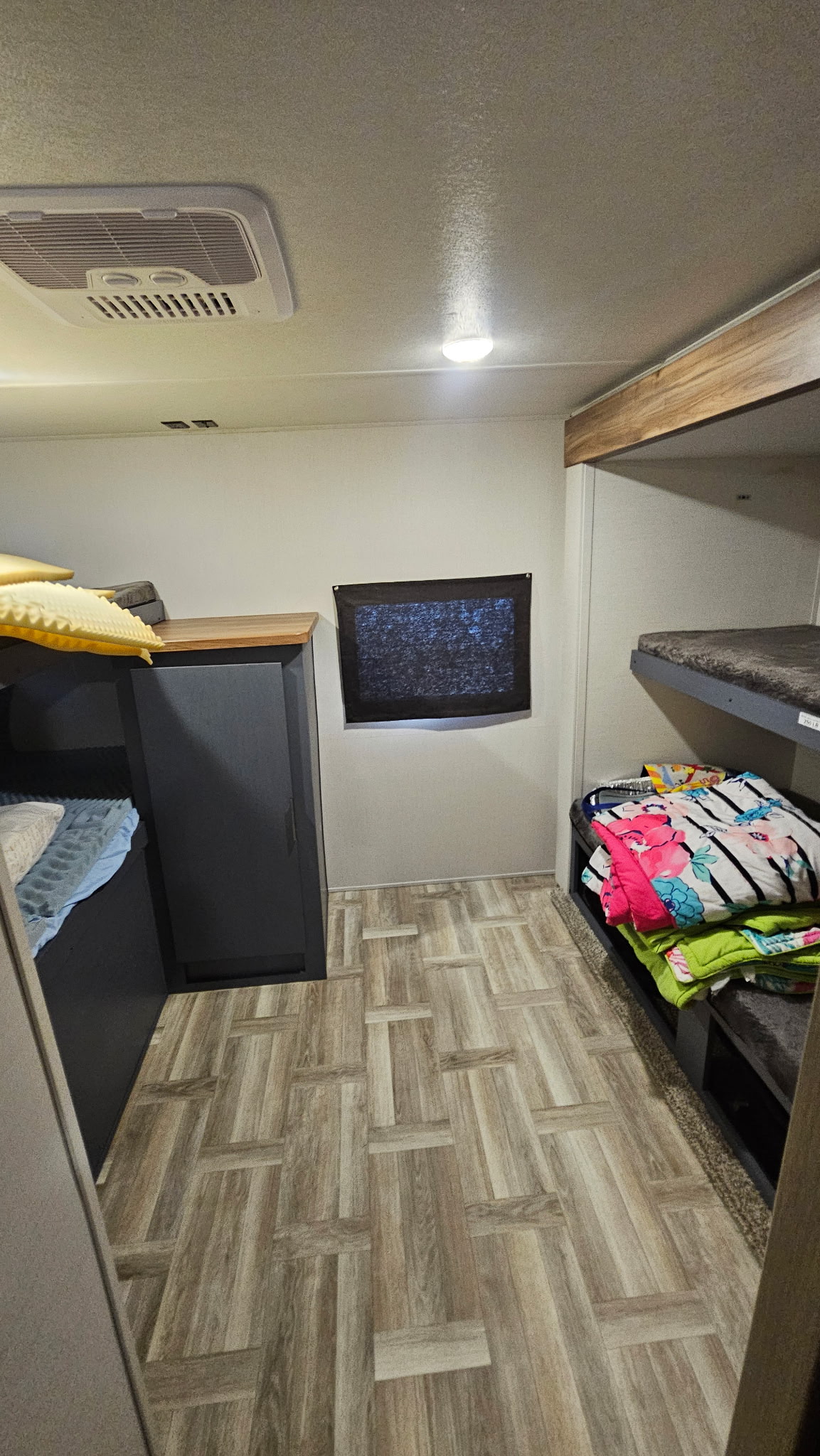 RV rental bunkhouse interior: showing comfortable bunk beds, storage, AC unit, and wood-look flooring.. Forest River Tracer 2024