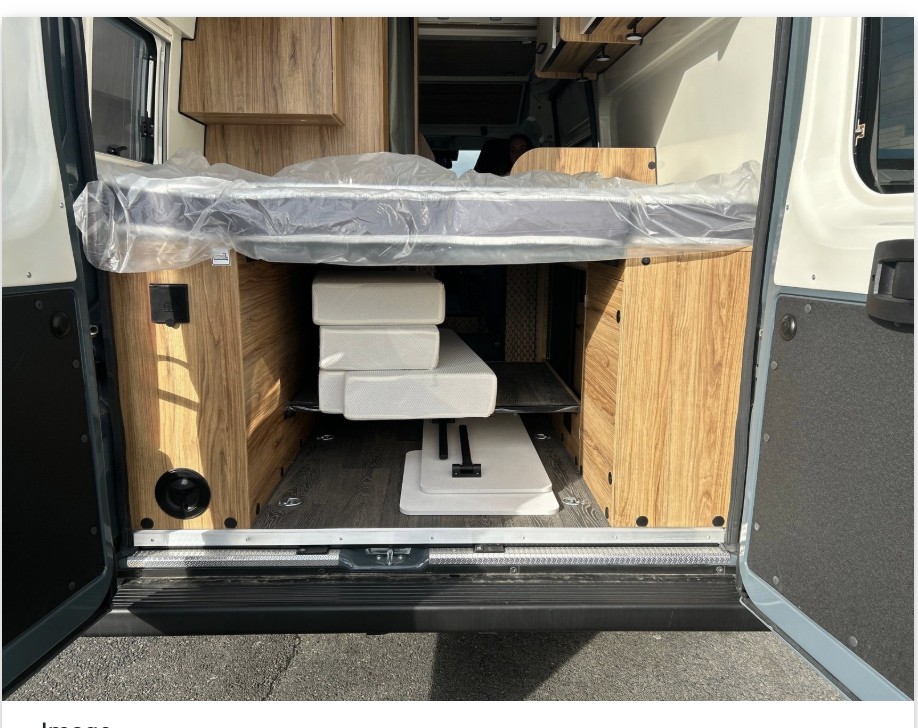 RV rental: Camper van's rear view, featuring a new, plastic-wrapped raised bed and versatile storage space below.. FONT VENDOME TERRAVAN 2025
