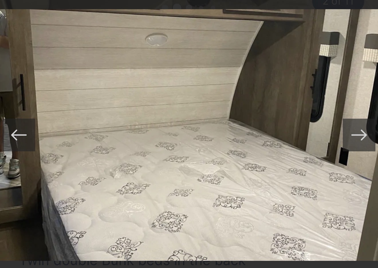 Spacious, modern RV rental bed with a fresh mattress, wood headboard, and interior light, perfect for comfortable travel.. Forest River Salem 2021